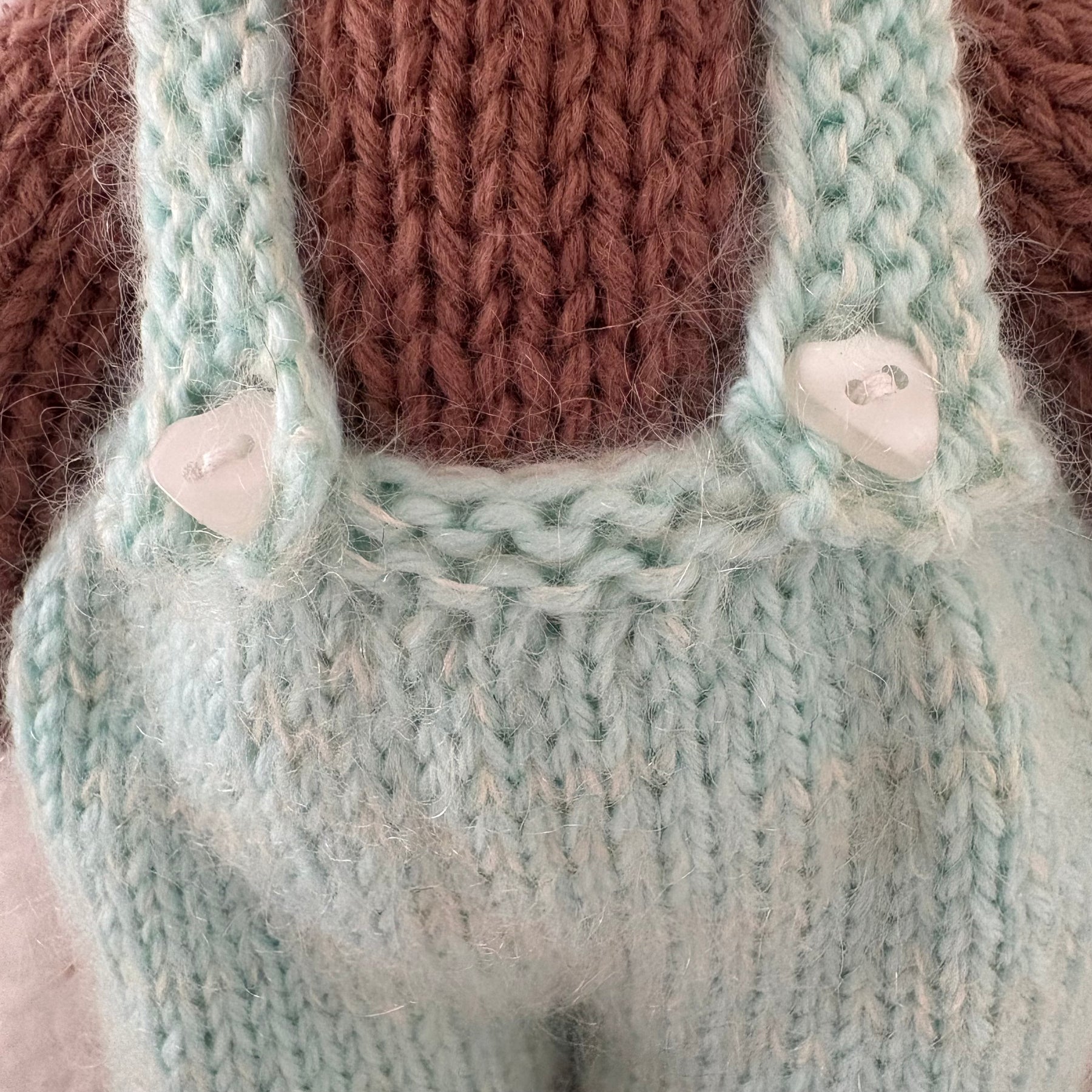 Little knitted bear in overalls, hat and scarf