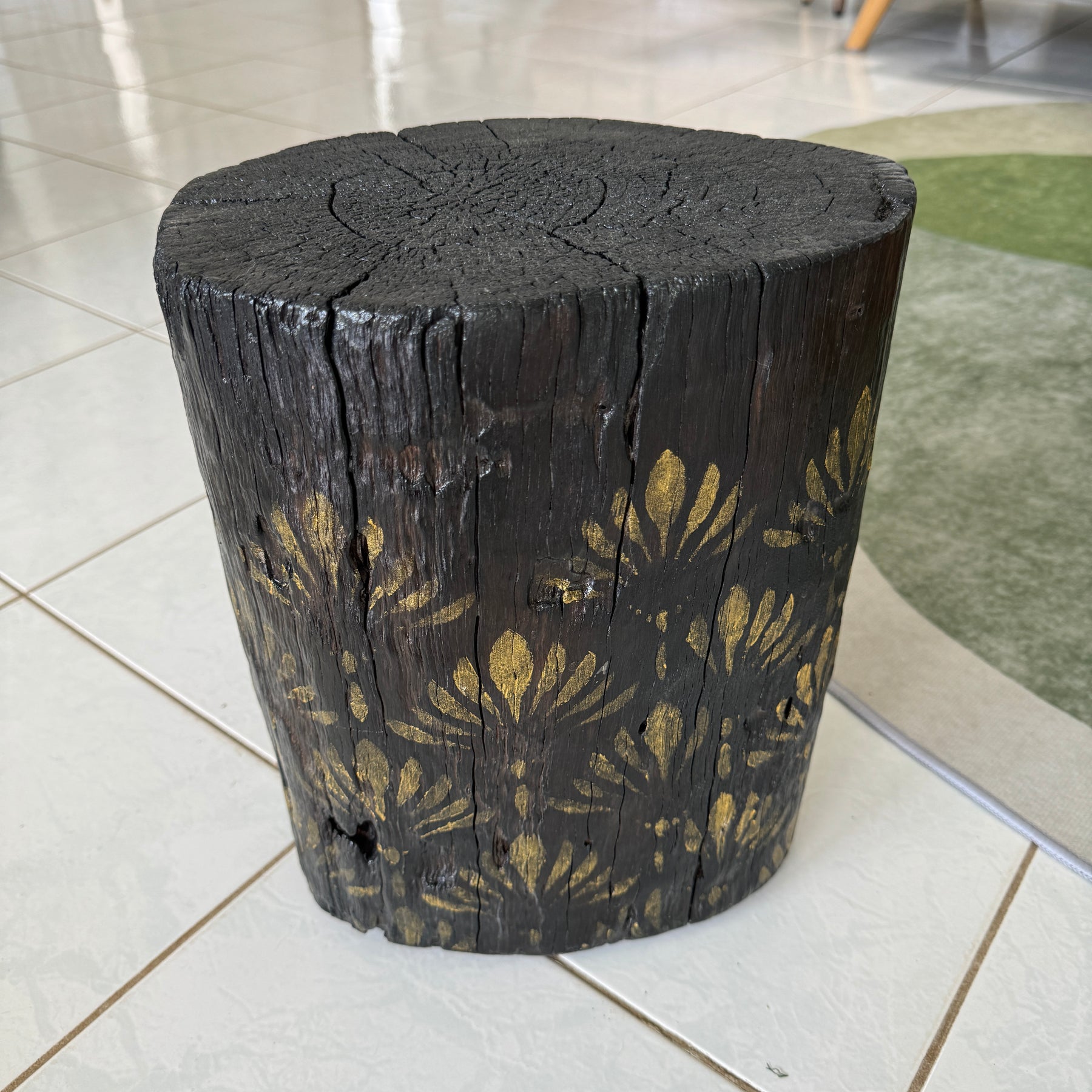Burnt Timber stump table featuring gold hand-painted artwork