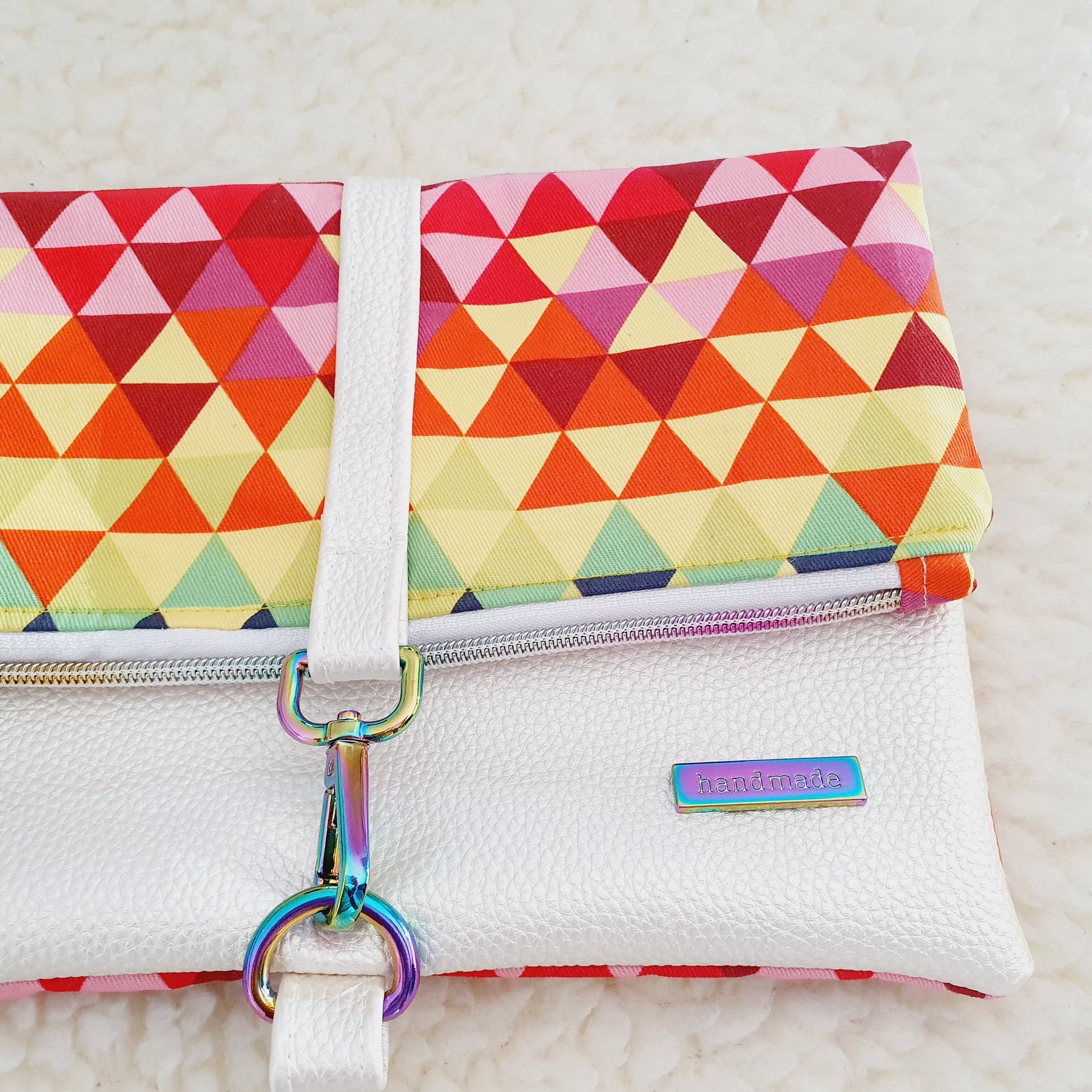 Modern, stylish white leatherette fold over zipper clutch with detachable strap