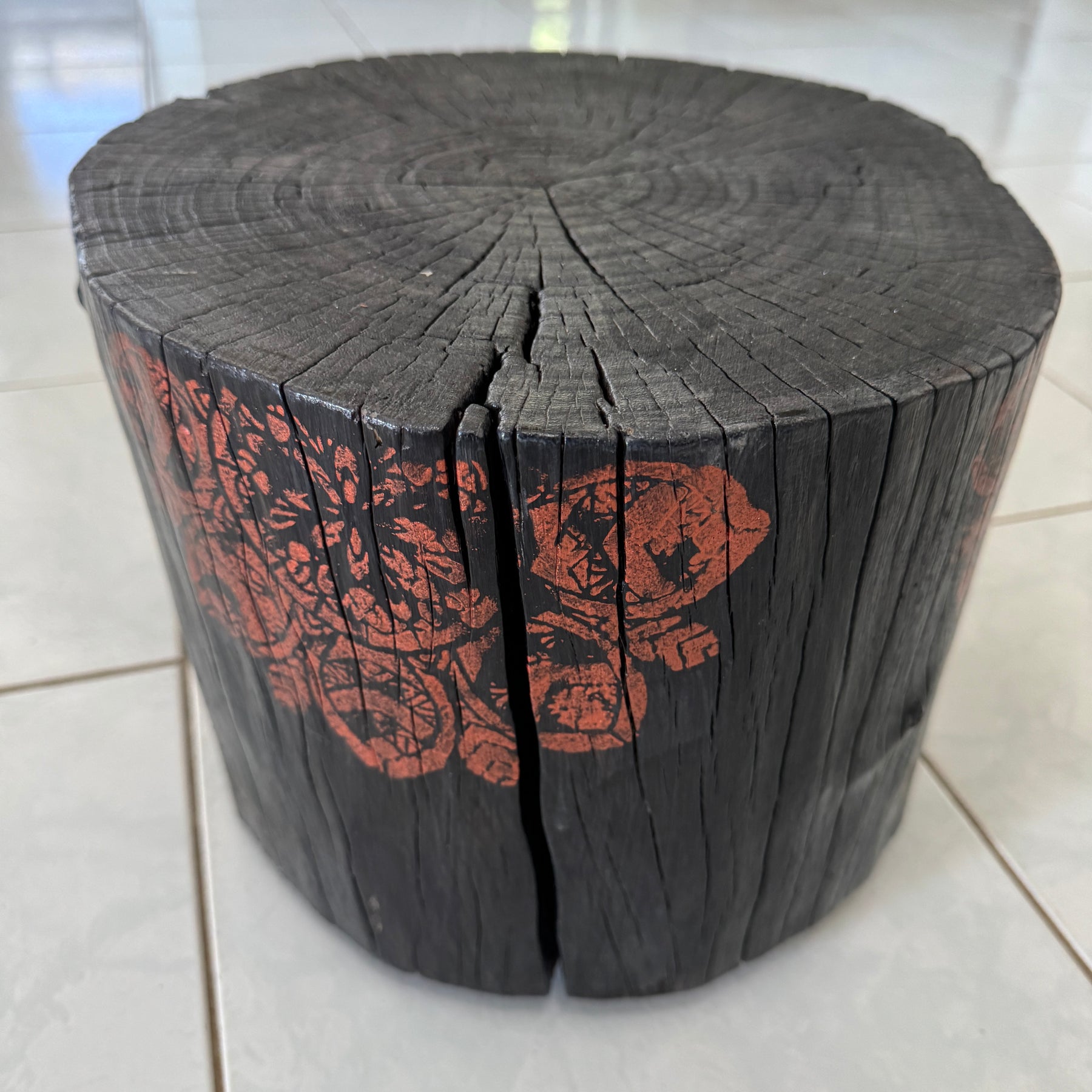 Burnt timber stump table featuring copper mandala artwork