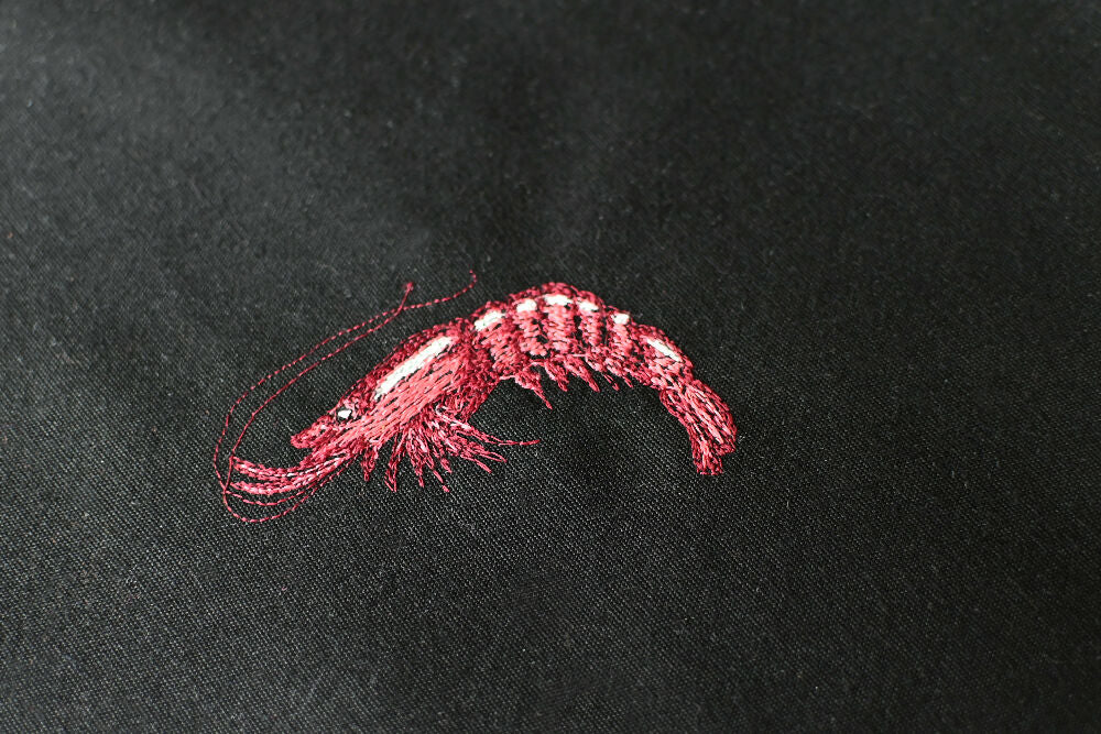 prawn free-hand embroidery on a black canvas