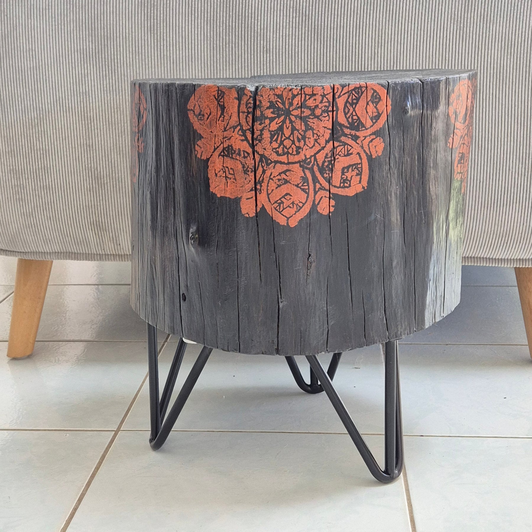 Burnt timber stump table featuring copper mandala artwork
