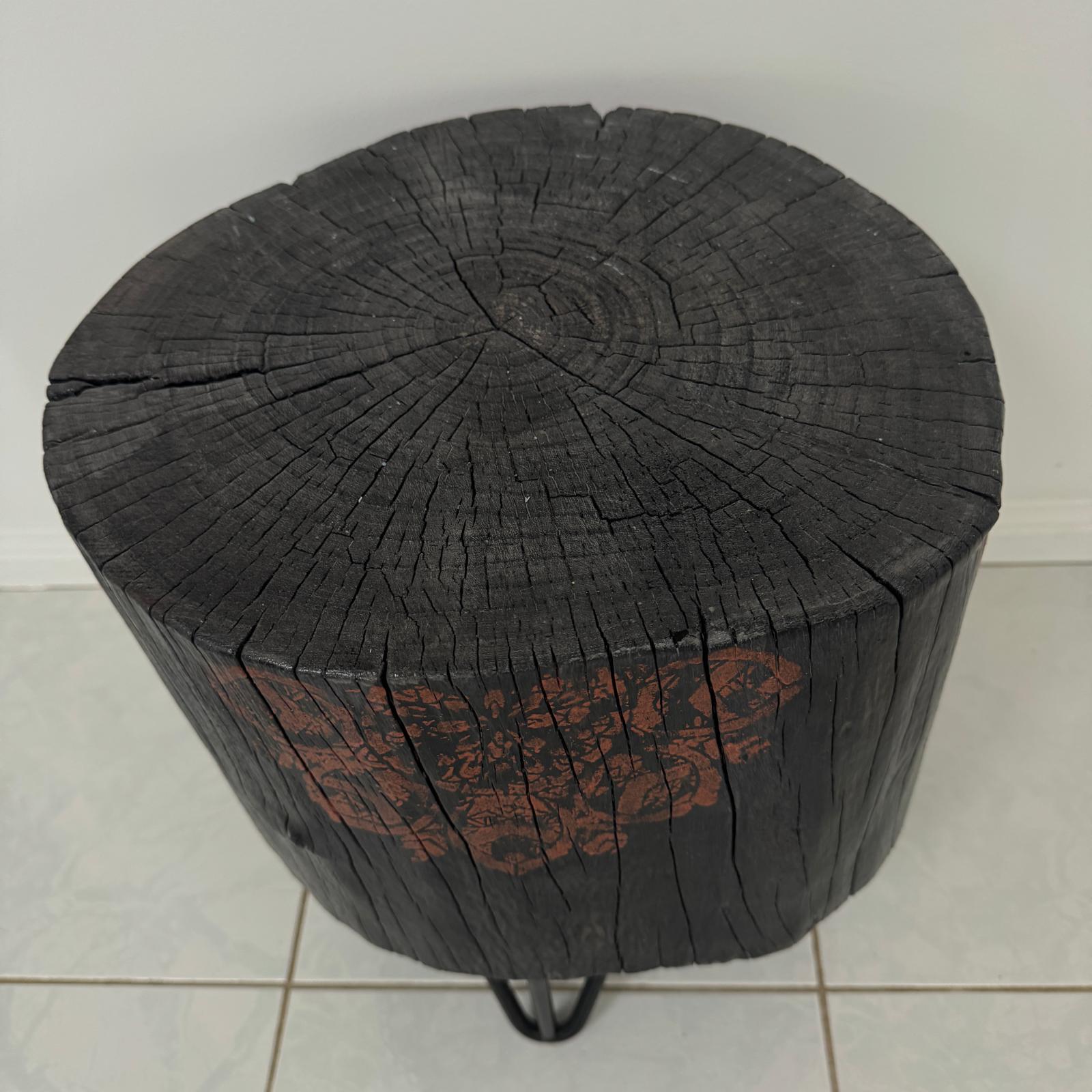 Burnt timber stump table featuring copper mandala artwork