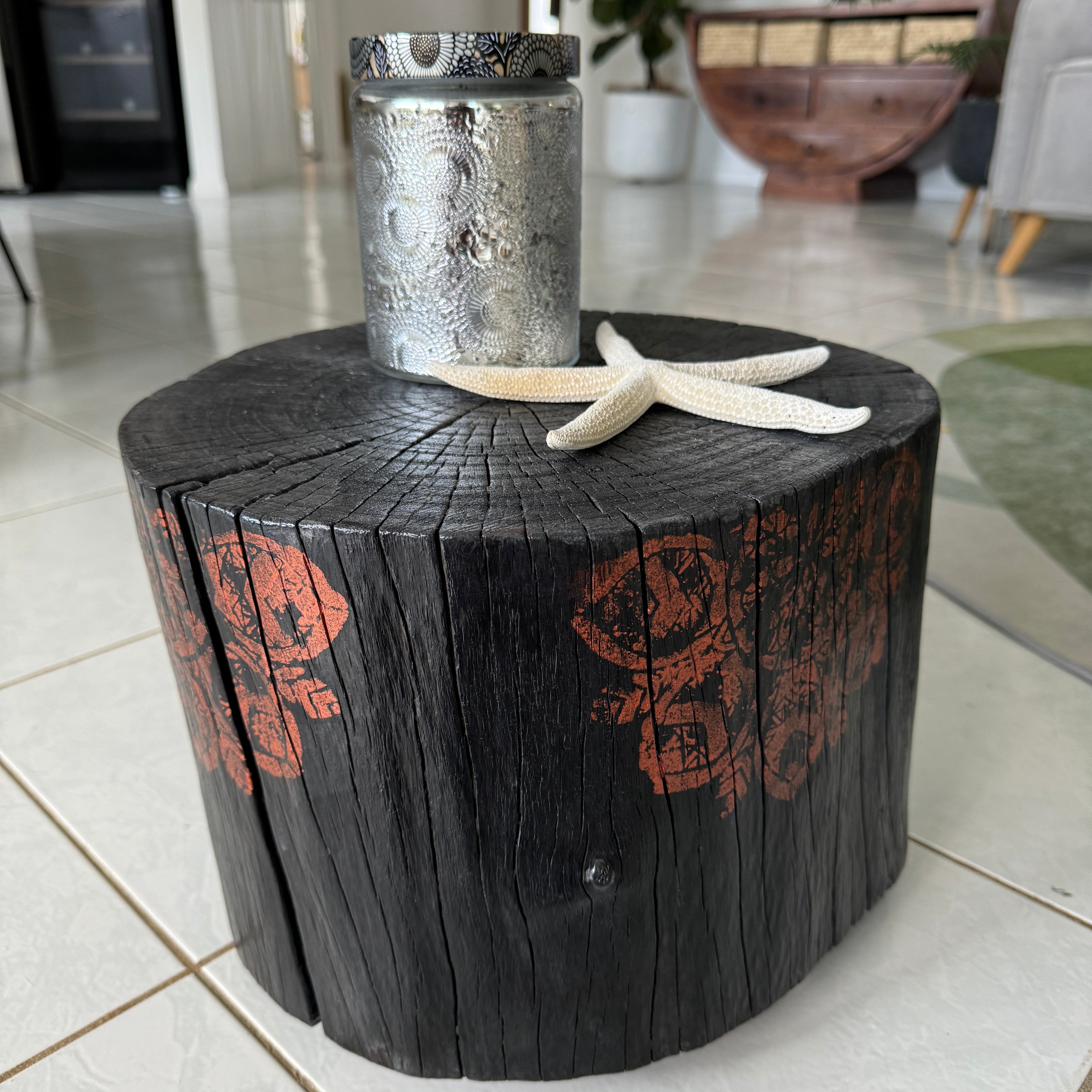 Burnt timber stump table featuring copper mandala artwork