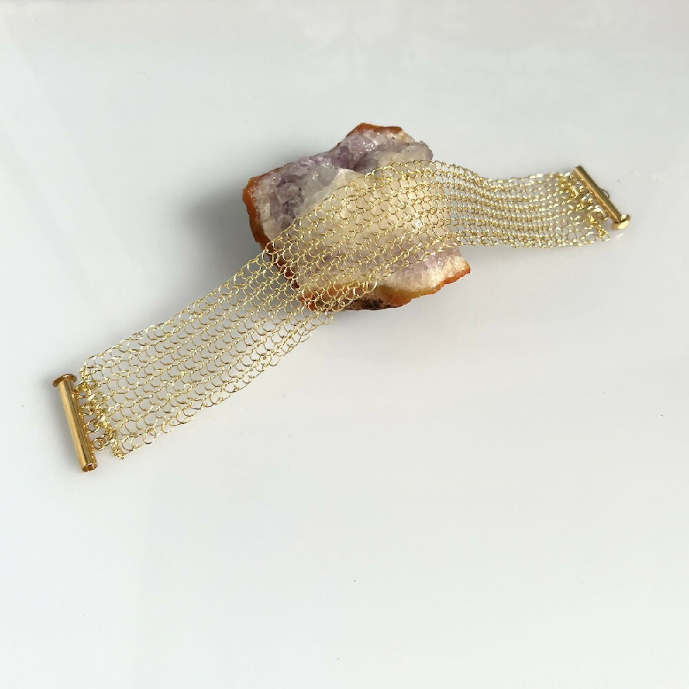 Knitted gold colour bracelet flat