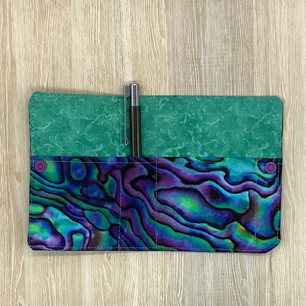 Paua shell refillable fabric pocket notepad cover with snap closure. Incl. book and pen.