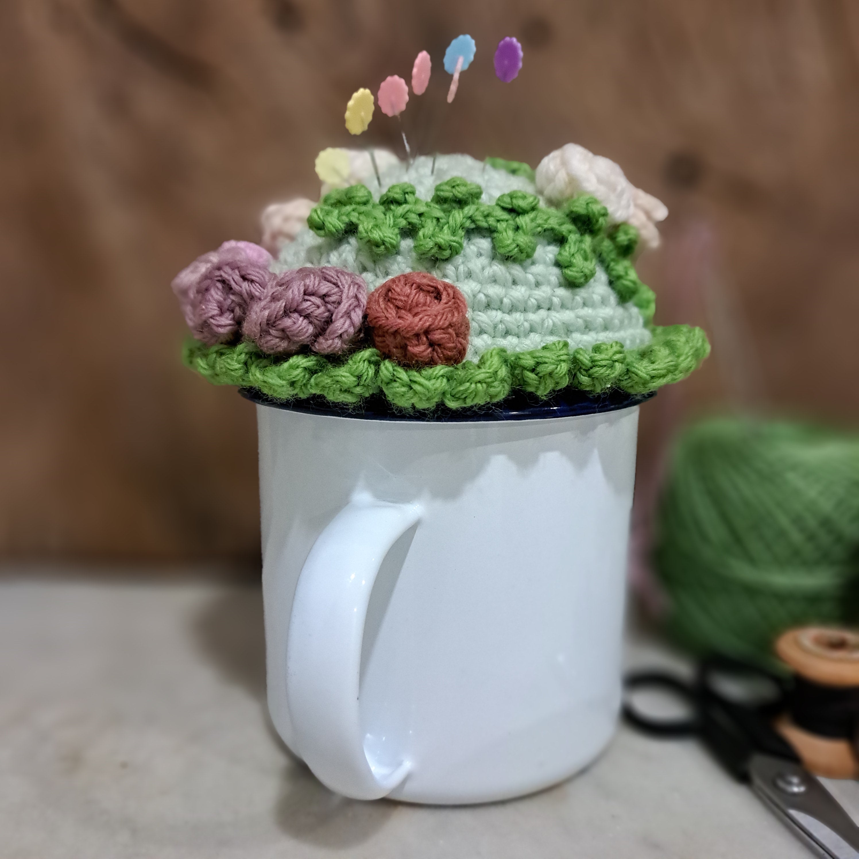Crochet pin cushion with pretty roses in a sturdy enamel tin mug