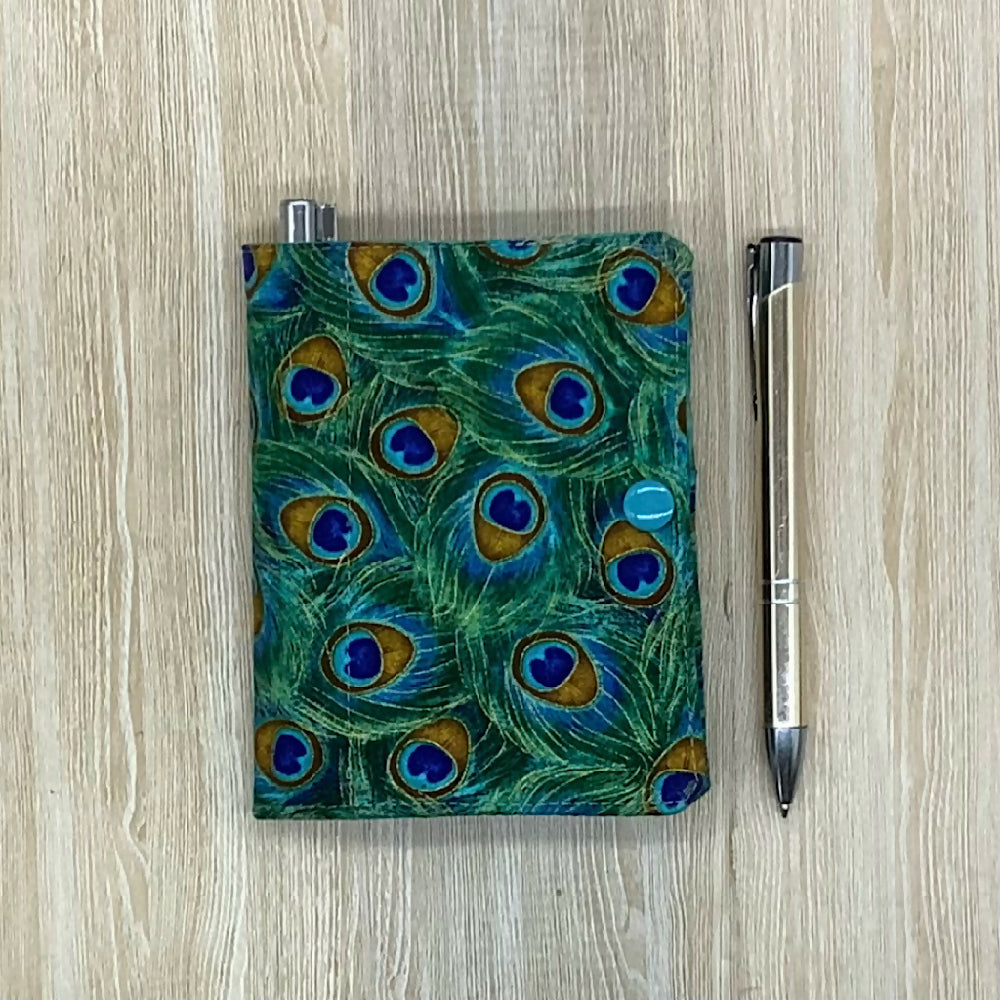 Peacock feathers refillable fabric pocket notepad cover with snap closure. Incl. book and pen.