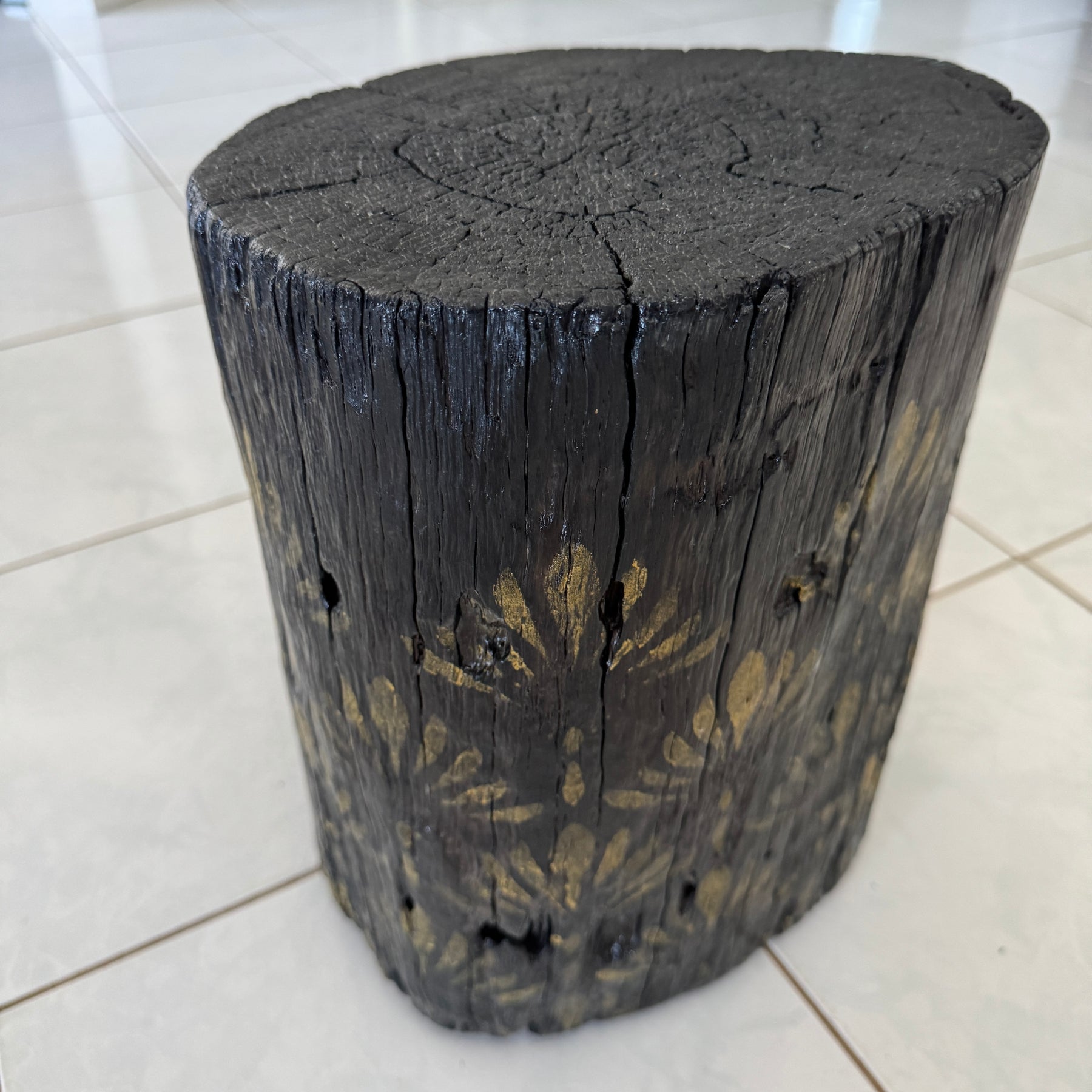 Burnt Timber stump table featuring gold hand-painted artwork