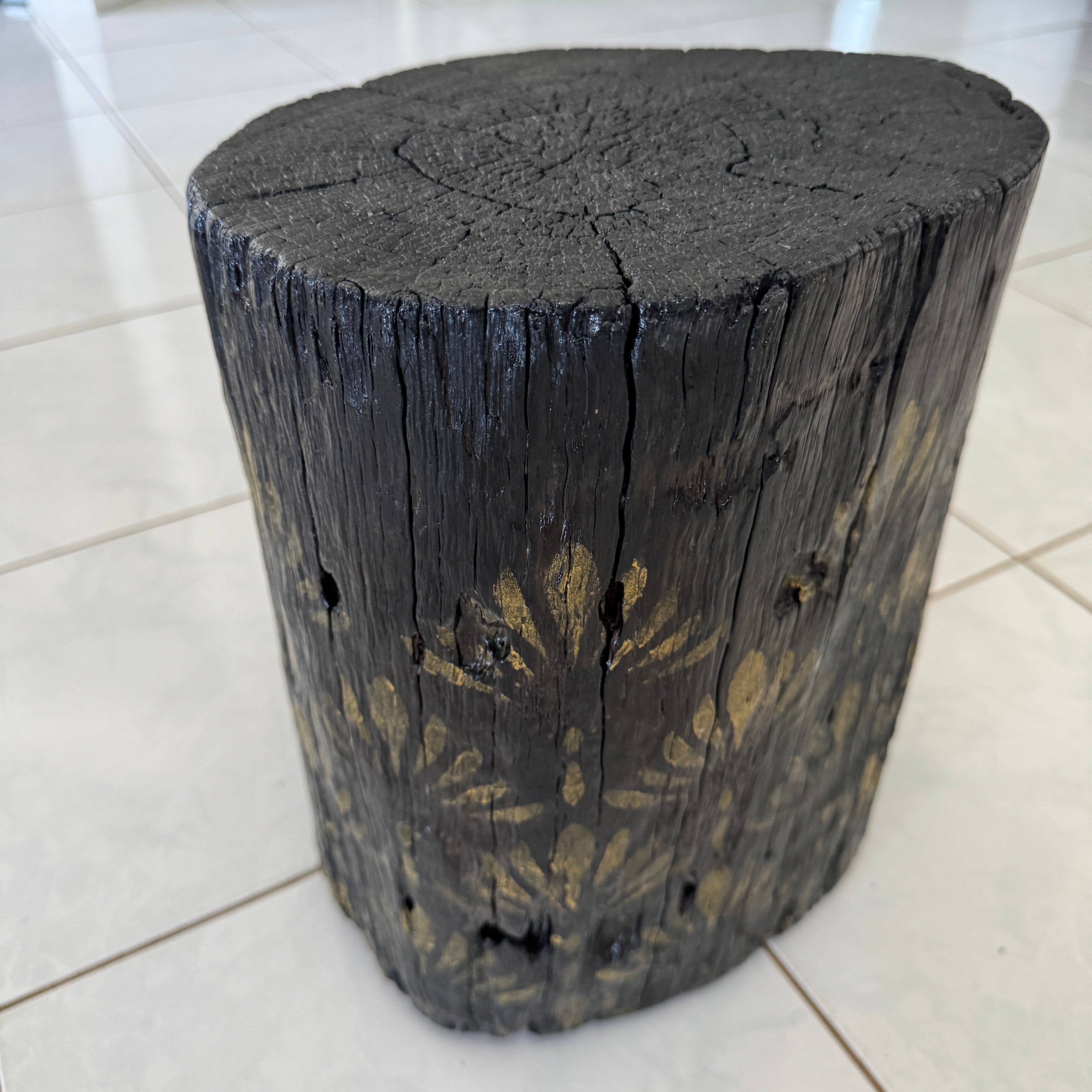 Burnt Timber stump table featuring gold hand-painted artwork