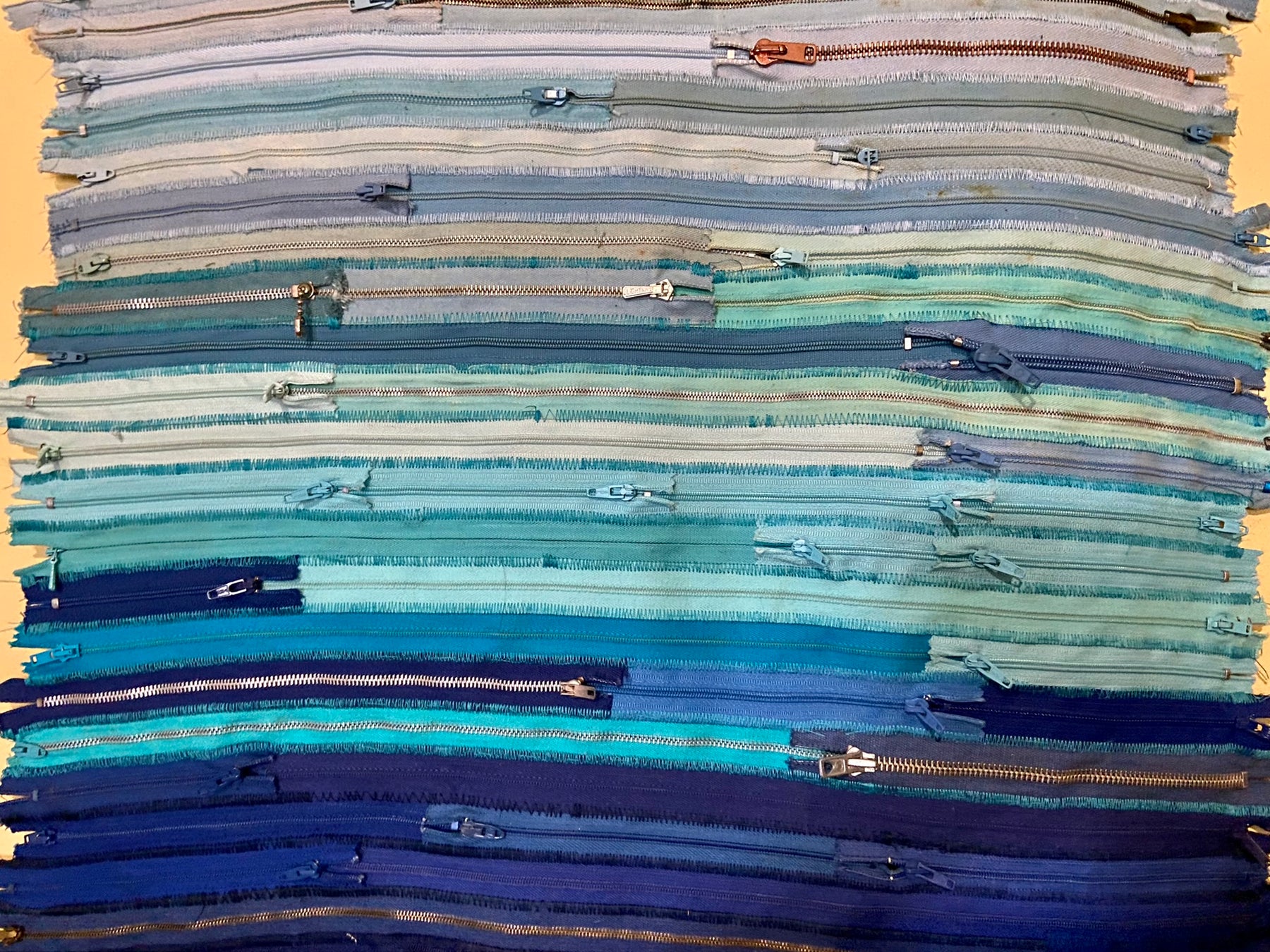 Upcycled 90 zips textile wall hanging. Ocean & Sky theme. Adorned with charms. Blue colour scheme. Ready to hang includes 2 x dowel rods