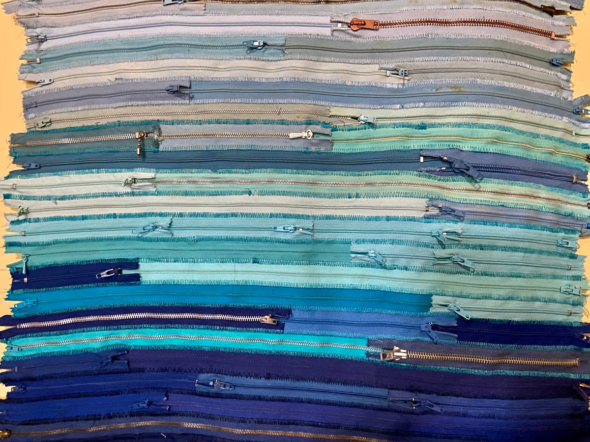 Upcycled 90 zips textile wall hanging. Ocean & Sky theme. Adorned with charms. Blue colour scheme. Ready to hang includes 2 x dowel rods