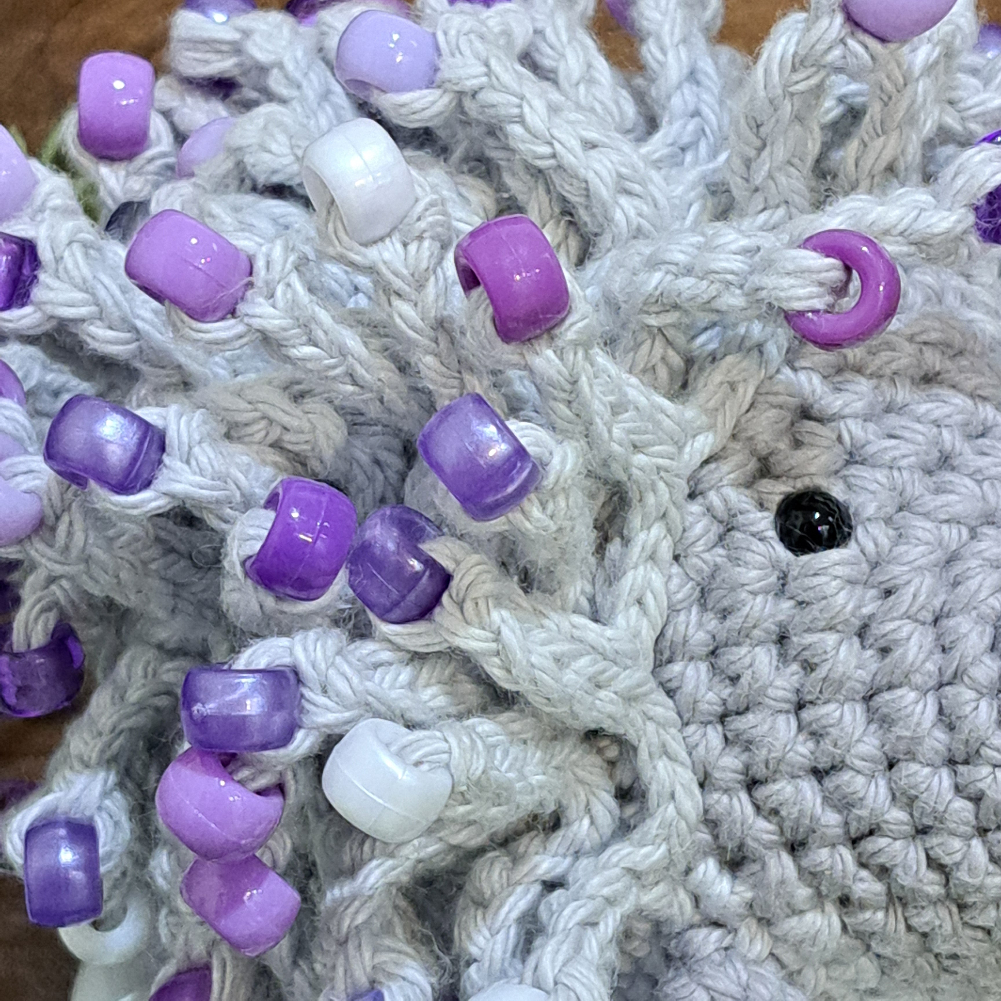 Handmade crochet echidna in grey cotton with mauve beads