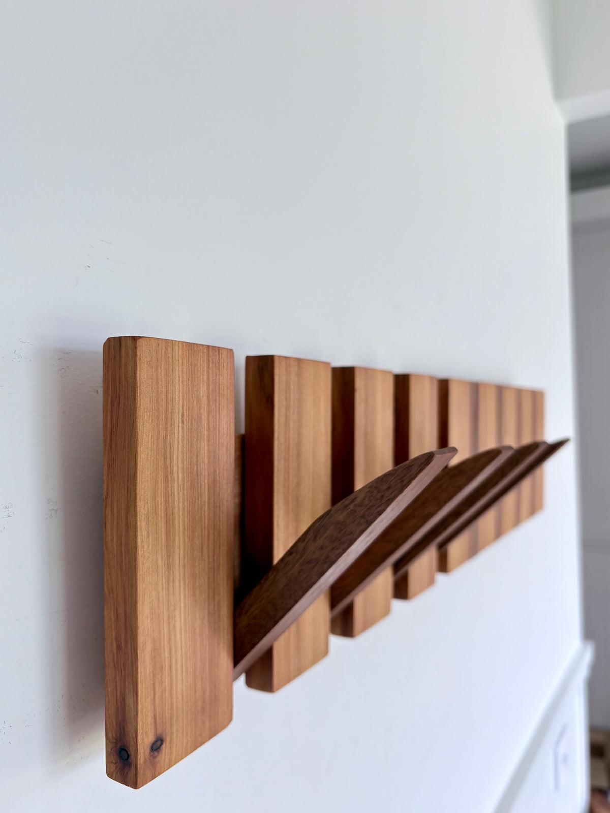 Two tone spotted gum and cypress horizon line piano style coatrack
