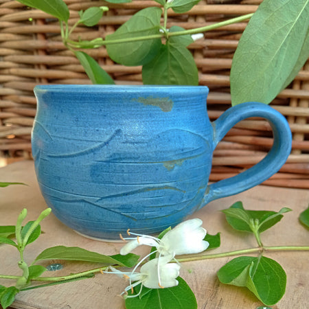 Blue ceramic mug with hand carved texture