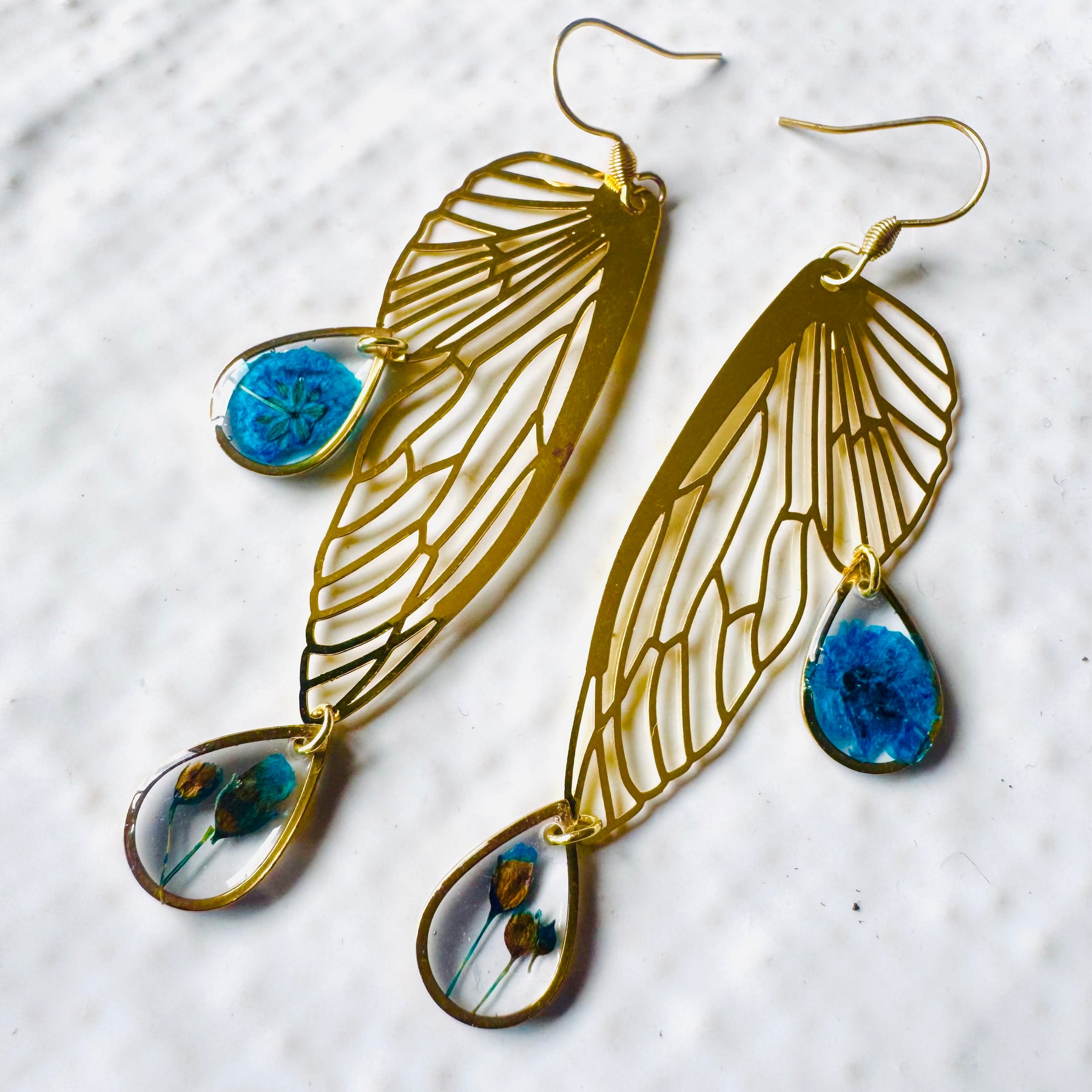 Butterfly resin earring with blue pressed flowers