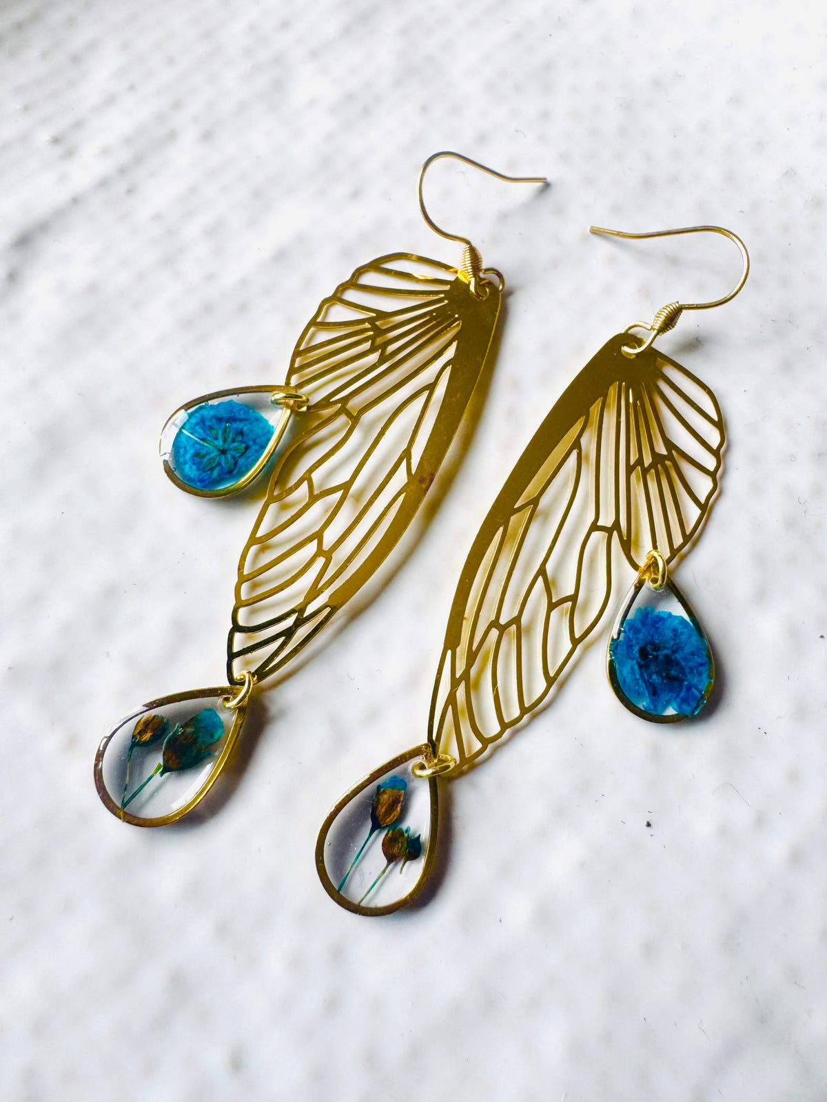Butterfly resin earring with blue pressed flowers
