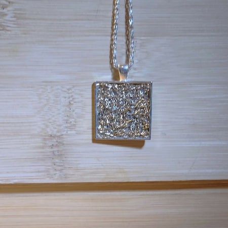 Pendant necklace. Gold crochet wire in silver frame.