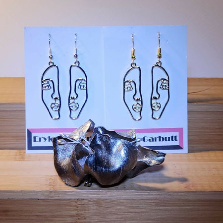 Dangle earrings. Face silhouette in gold or silver.