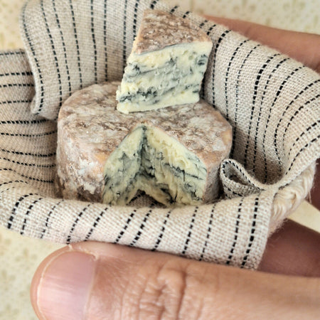 Blue cheese wheel with cut wedge