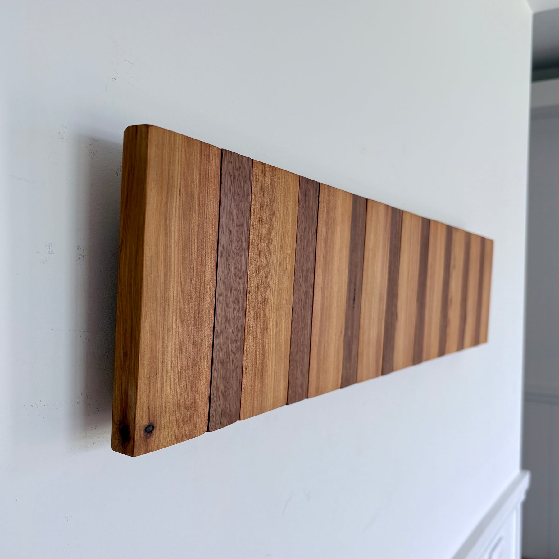 Two tone spotted gum and cypress horizon line piano style coatrack