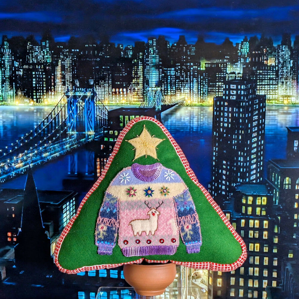 Rudolph Llama cushion with city background.