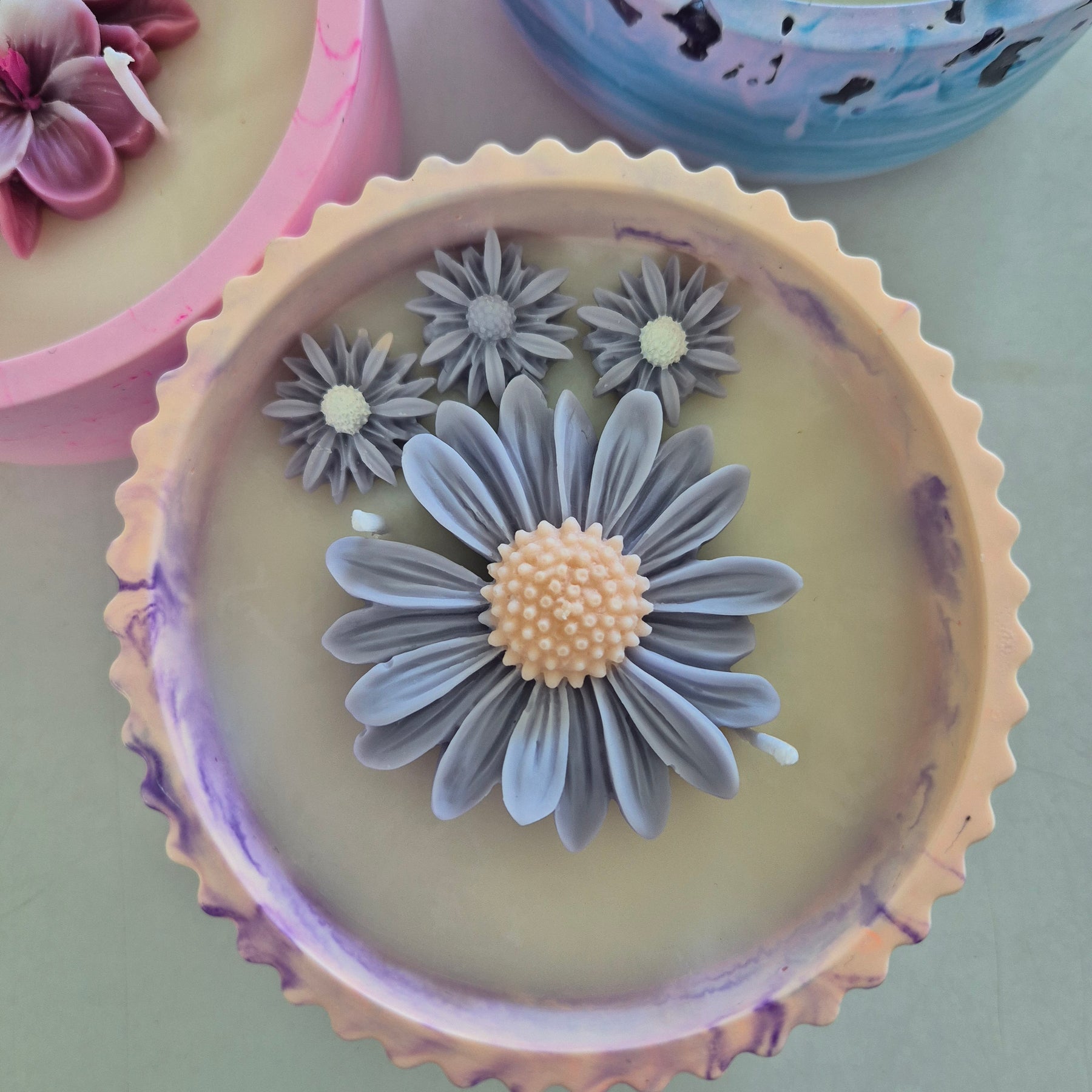 Round orange and purple concrete bowl candle with rose and lavender scent