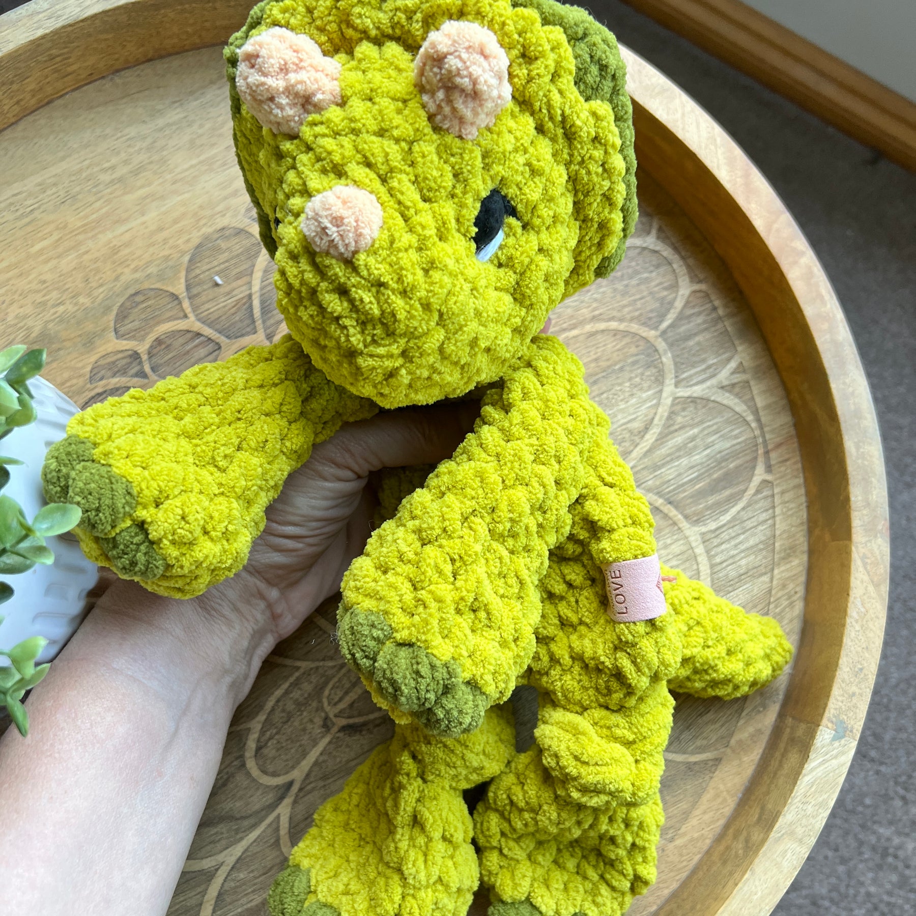 Handmade modern crochet Triceratops lovey snuggler with knotted legs baby safe.