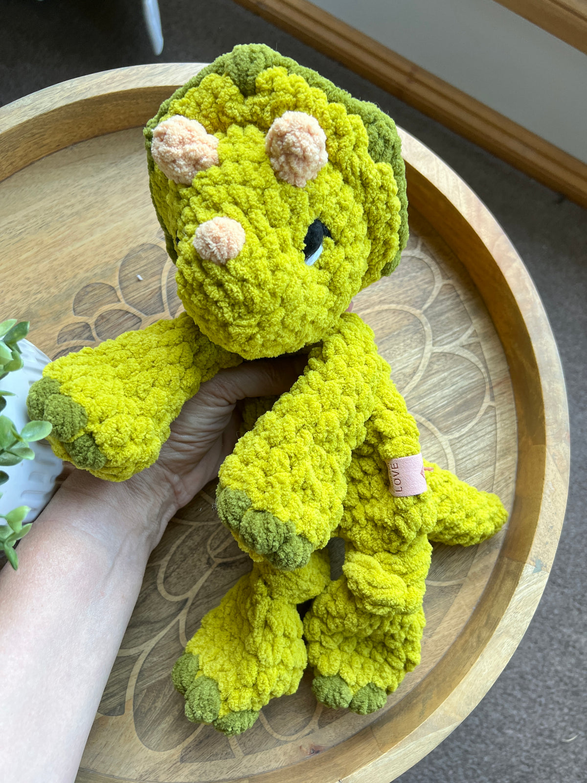 Handmade modern crochet Triceratops lovey snuggler with knotted legs baby safe.