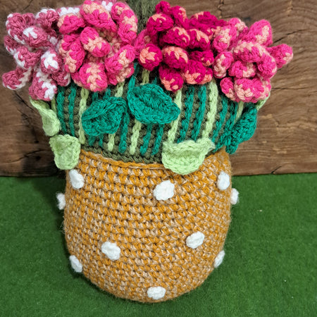 Crochet doorstop/ pink flowers in a terracotta vase.