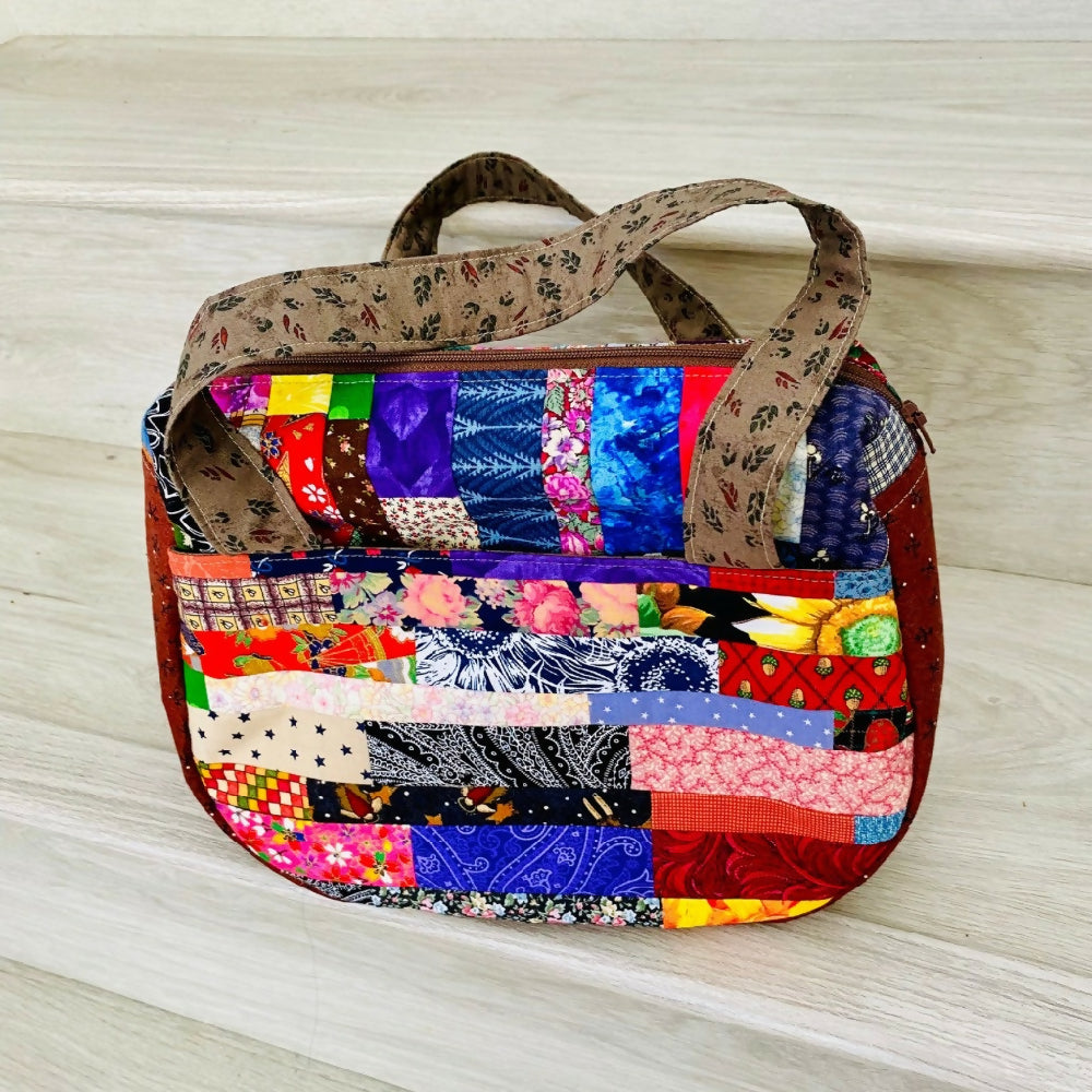 Compact curved gusseted patchwork handbag