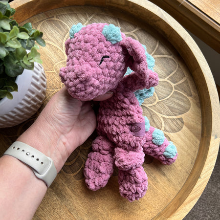 Handmade crochet Mini Dragon modern lovey with knotted legs and rainbow spikes.