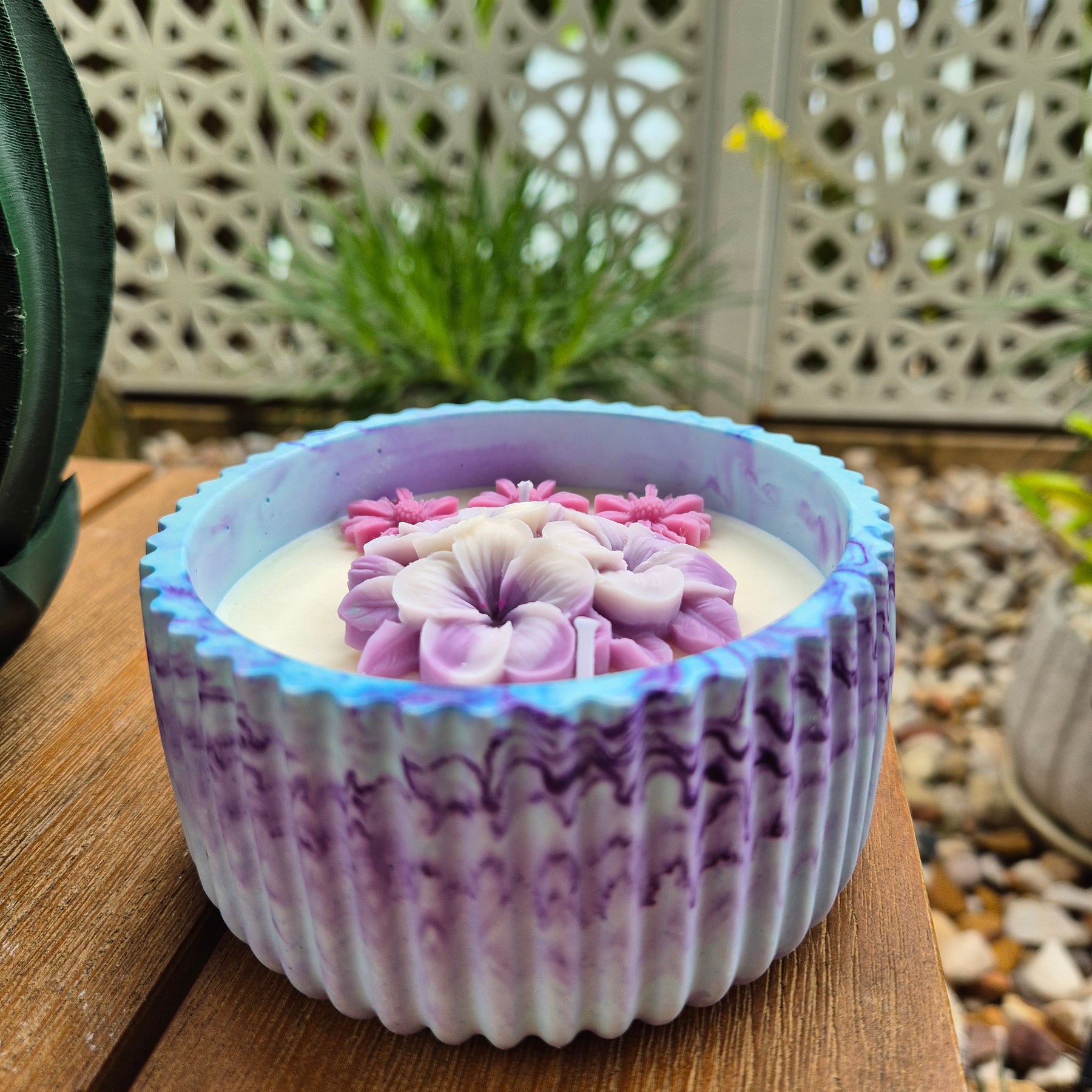 Round blue and purple concrete bowl candle with frangipani flower