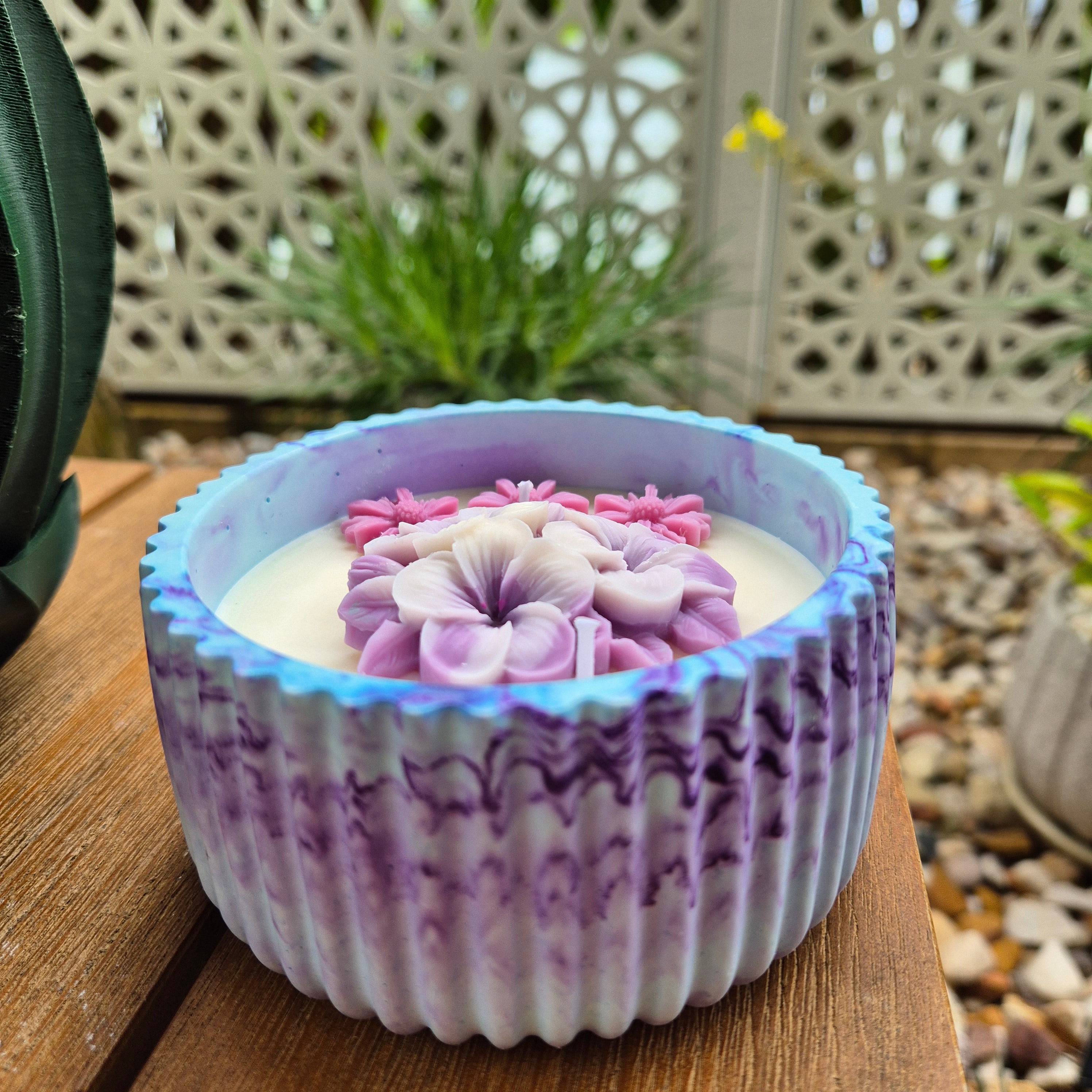 Round blue and purple concrete bowl candle with frangipani flower