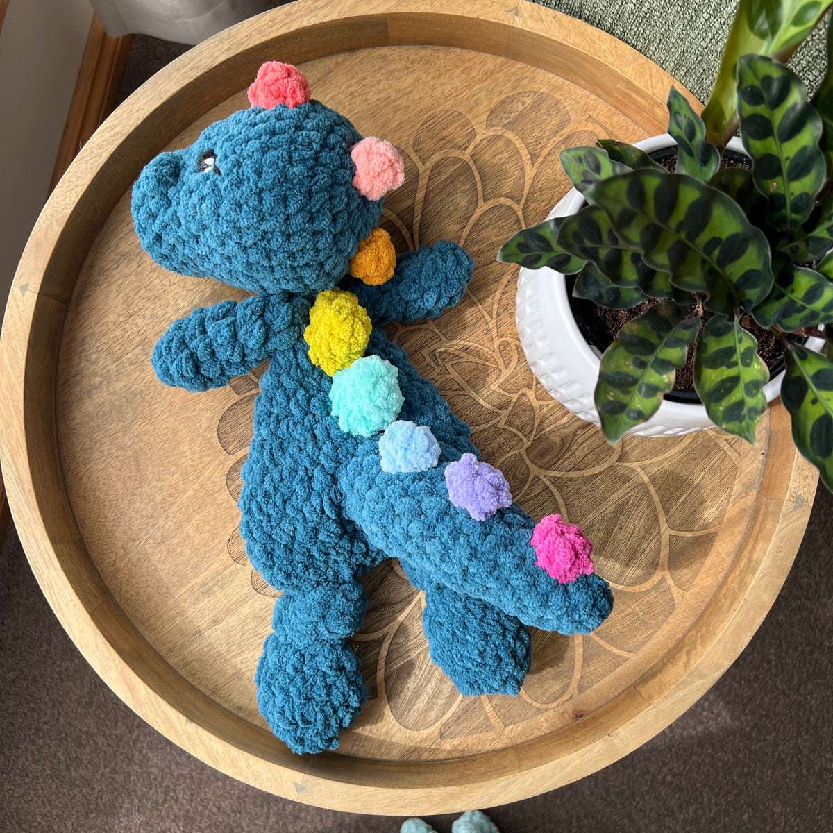 Handmade crochet Dinosaur modern lovey with knotted legs and rainbow spikes.