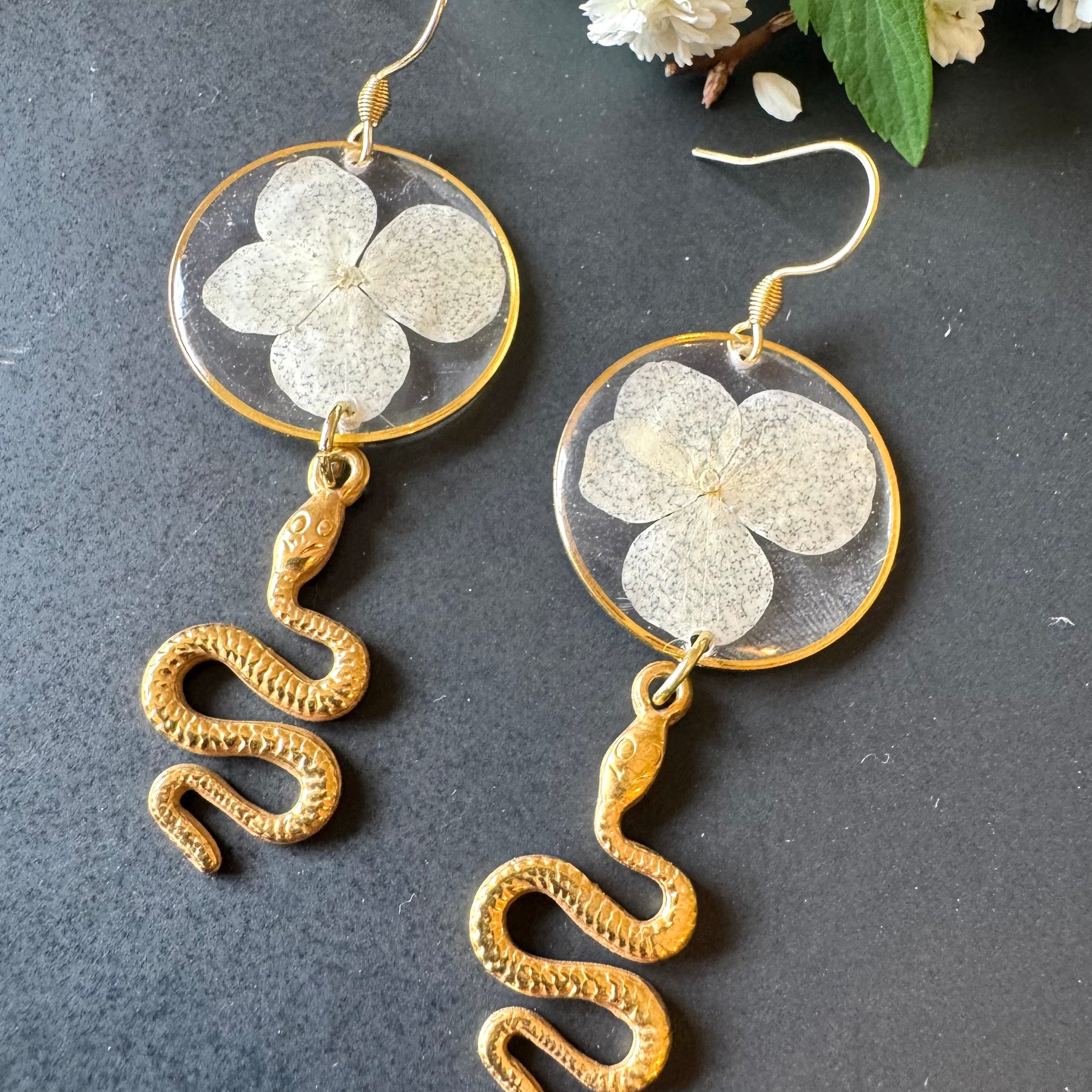 White pressed flower resin earrings with gold snake