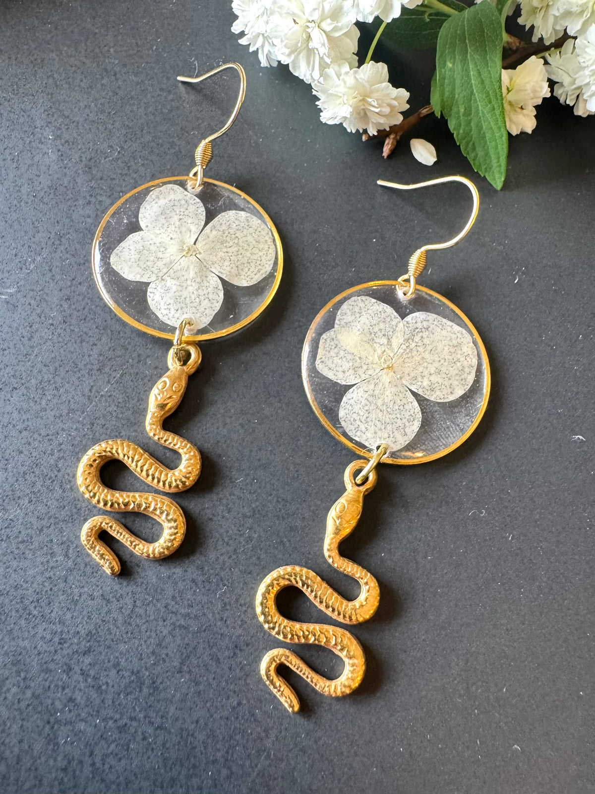 White pressed flower resin earrings with gold snake