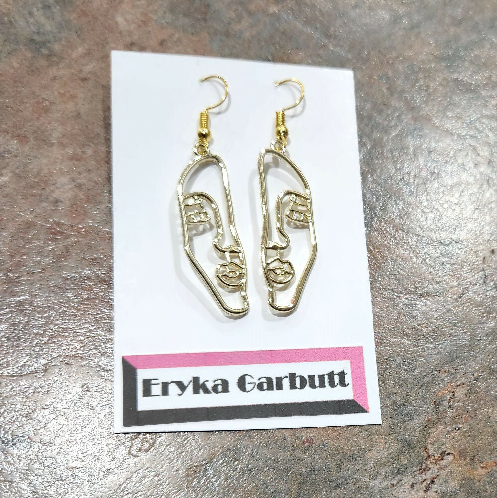 Dangle earrings. Face silhouette in gold or silver.