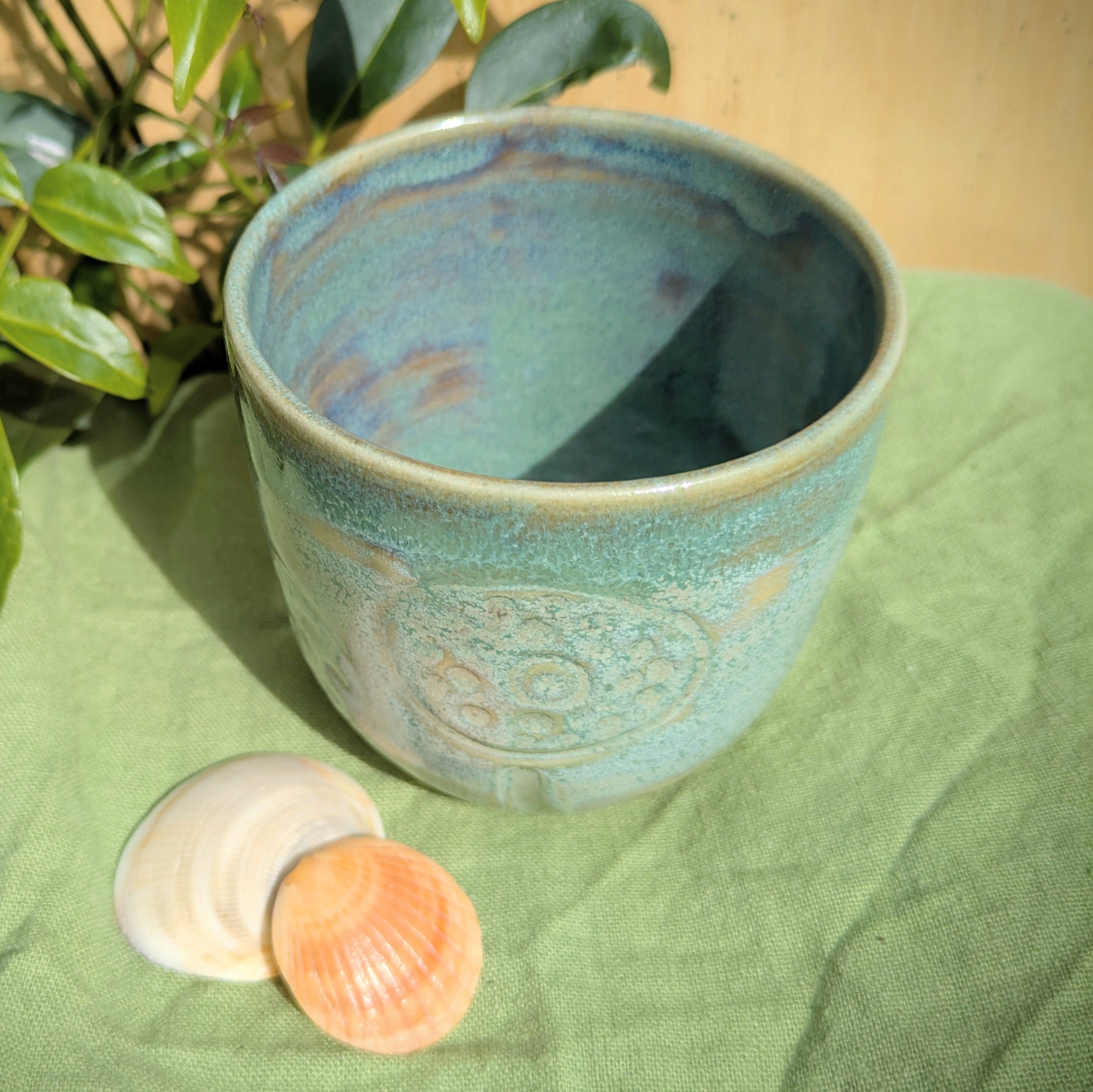 Cup in soft, mottled mossy greens and warm sandy colour
