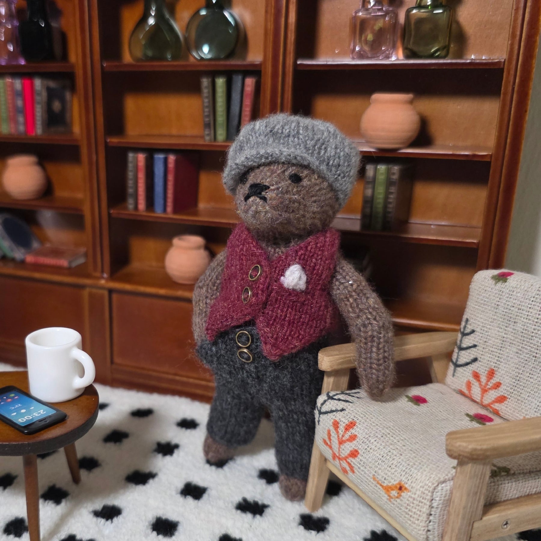 Small hand knitted bear with removeable clothes