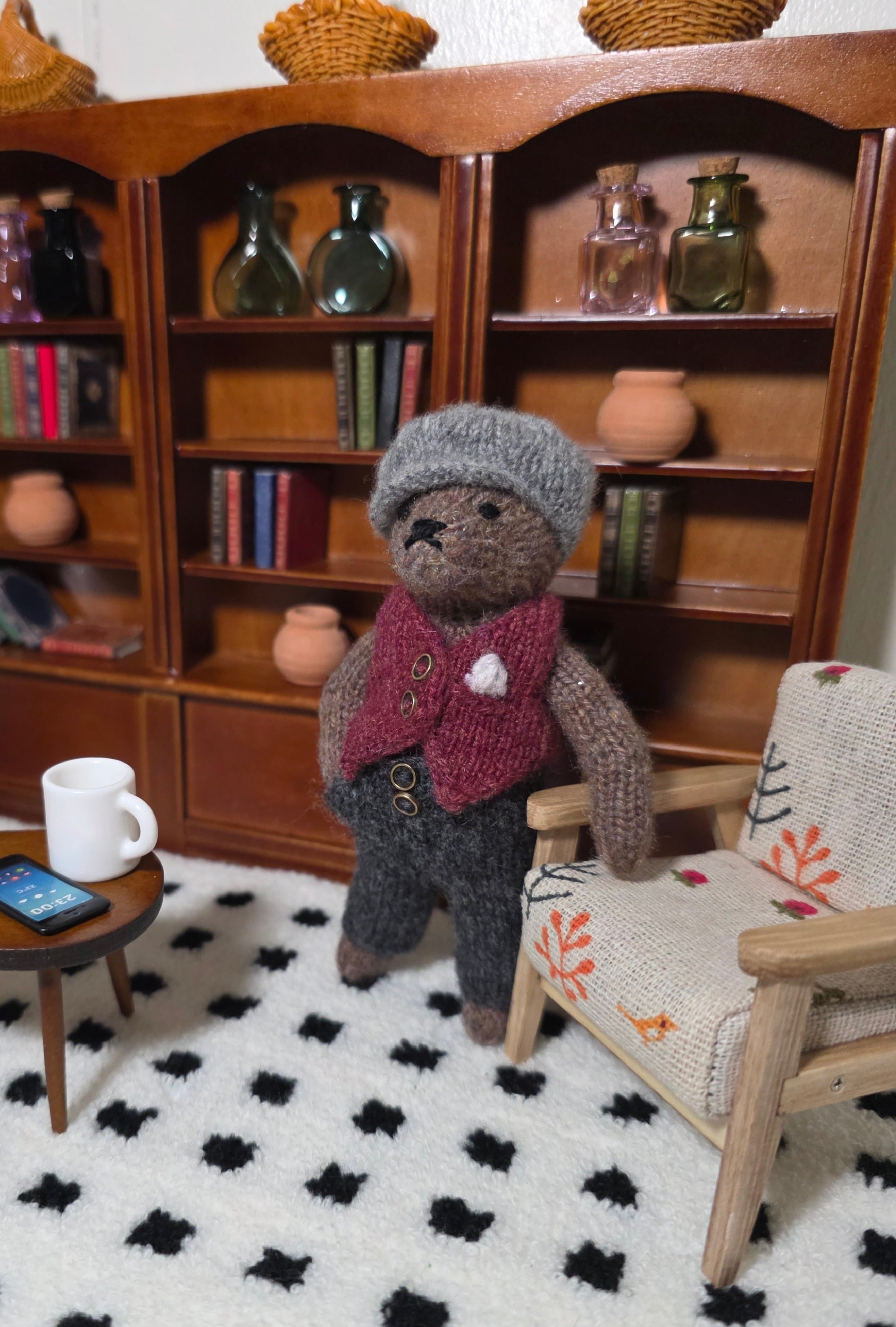 Small hand knitted bear with removeable clothes
