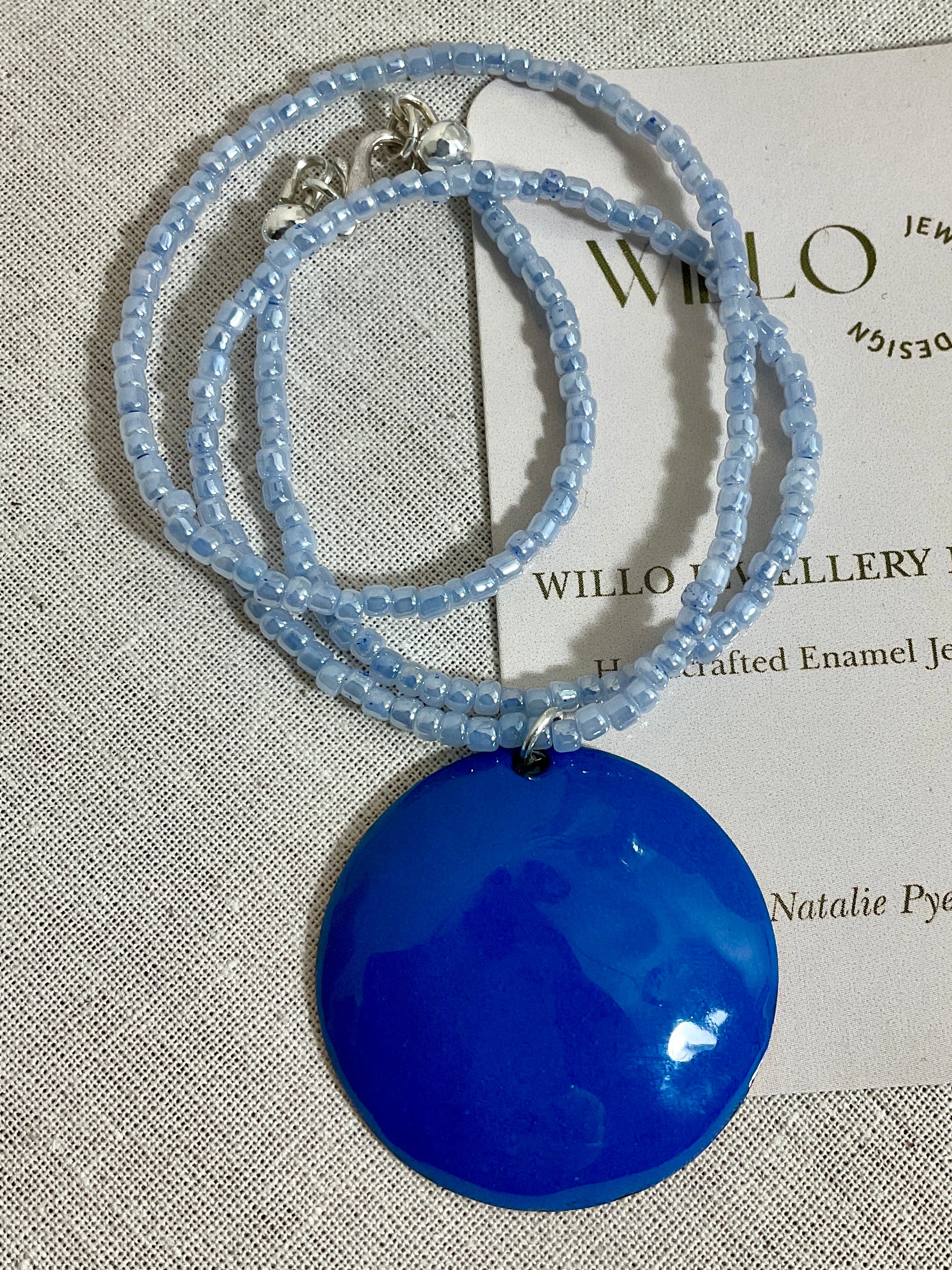 Blue enamel pendant on glass seed bead necklace.