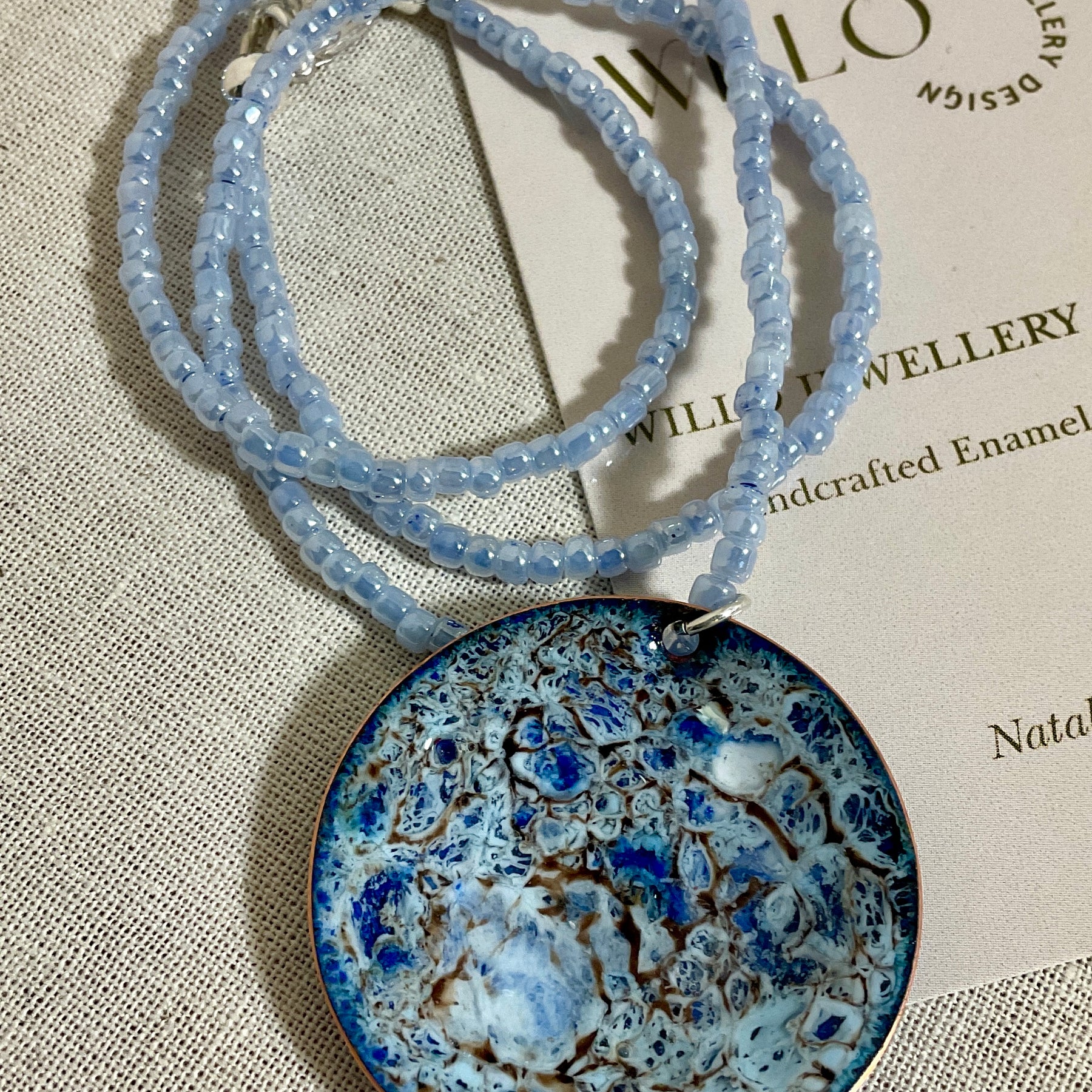 Blue enamel pendant on glass seed bead necklace.