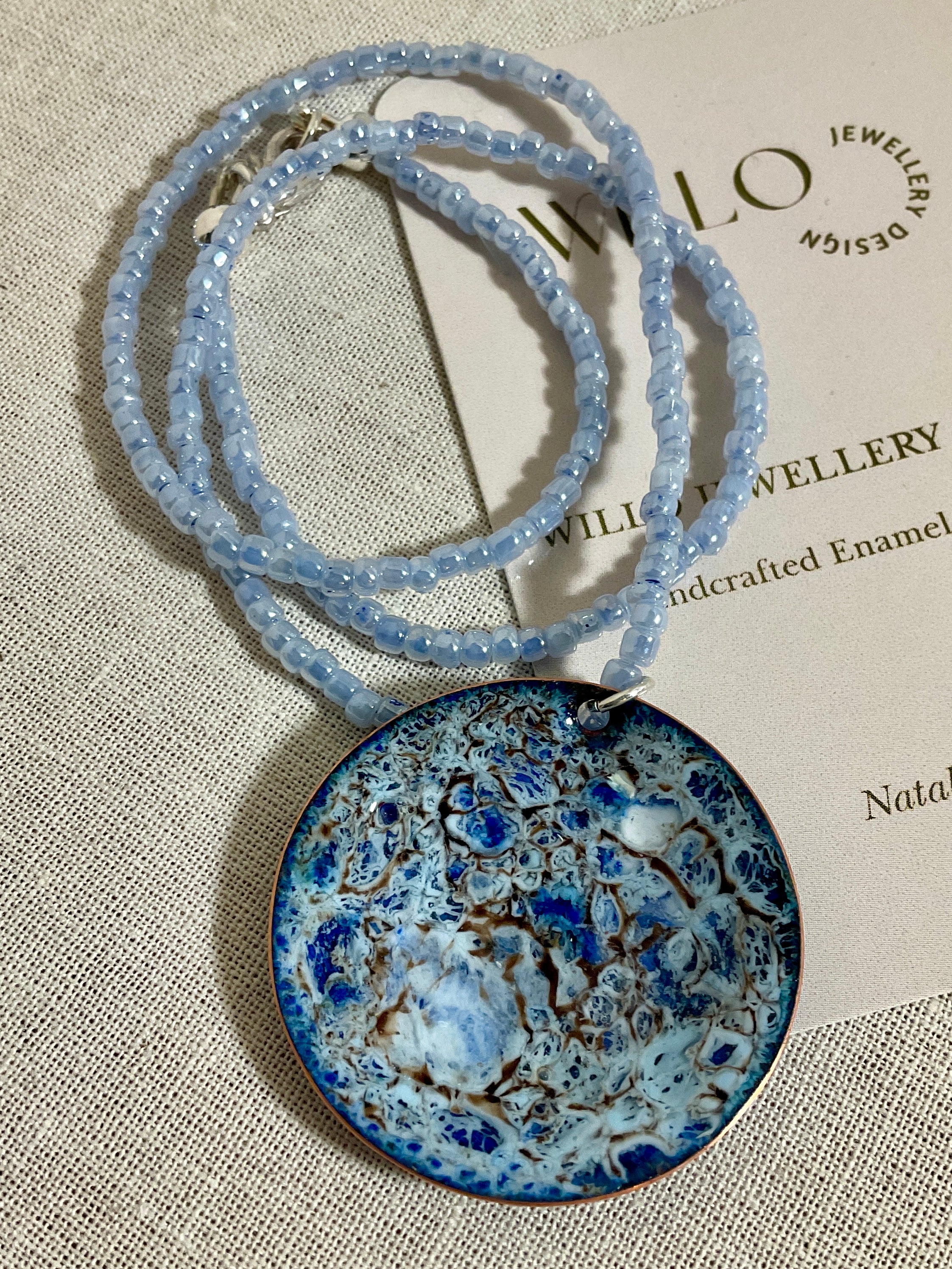 Blue enamel pendant on glass seed bead necklace.