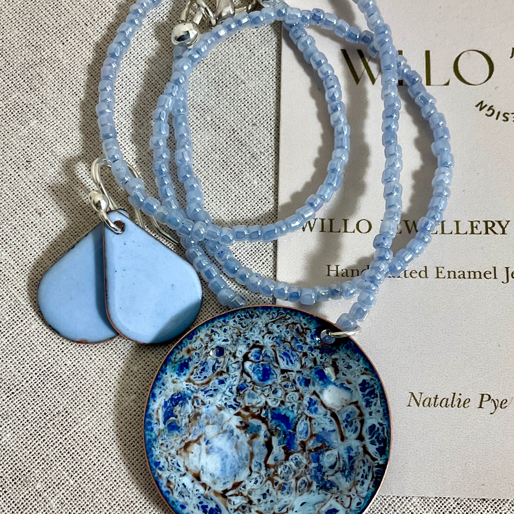 Blue enamel pendant on glass seed bead necklace.