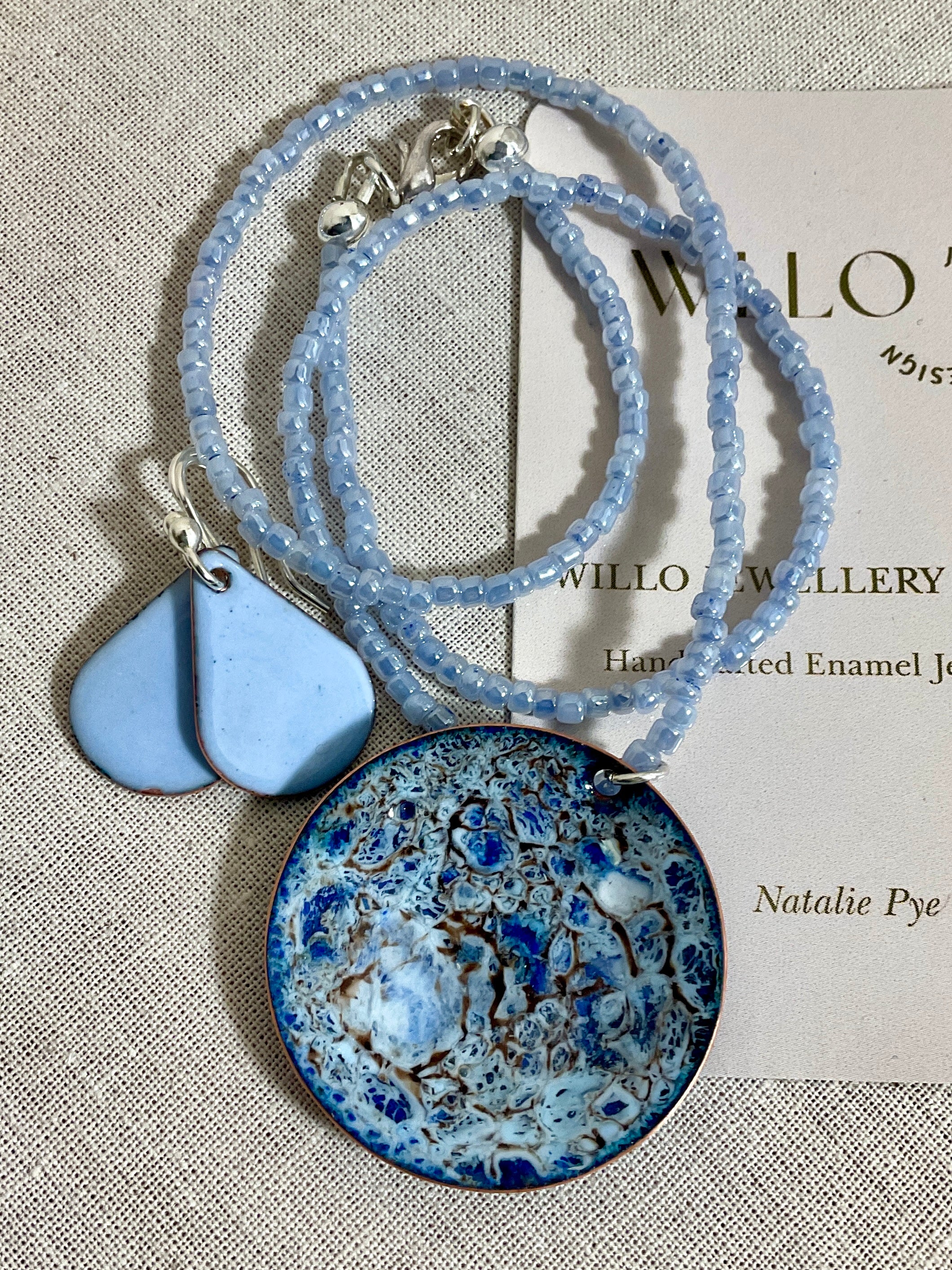 Blue enamel pendant on glass seed bead necklace.