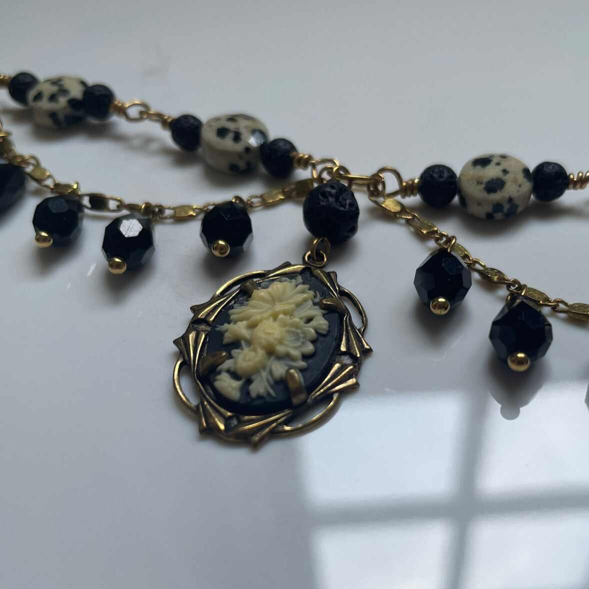 Black and brass beaded statement necklace with cameo charm