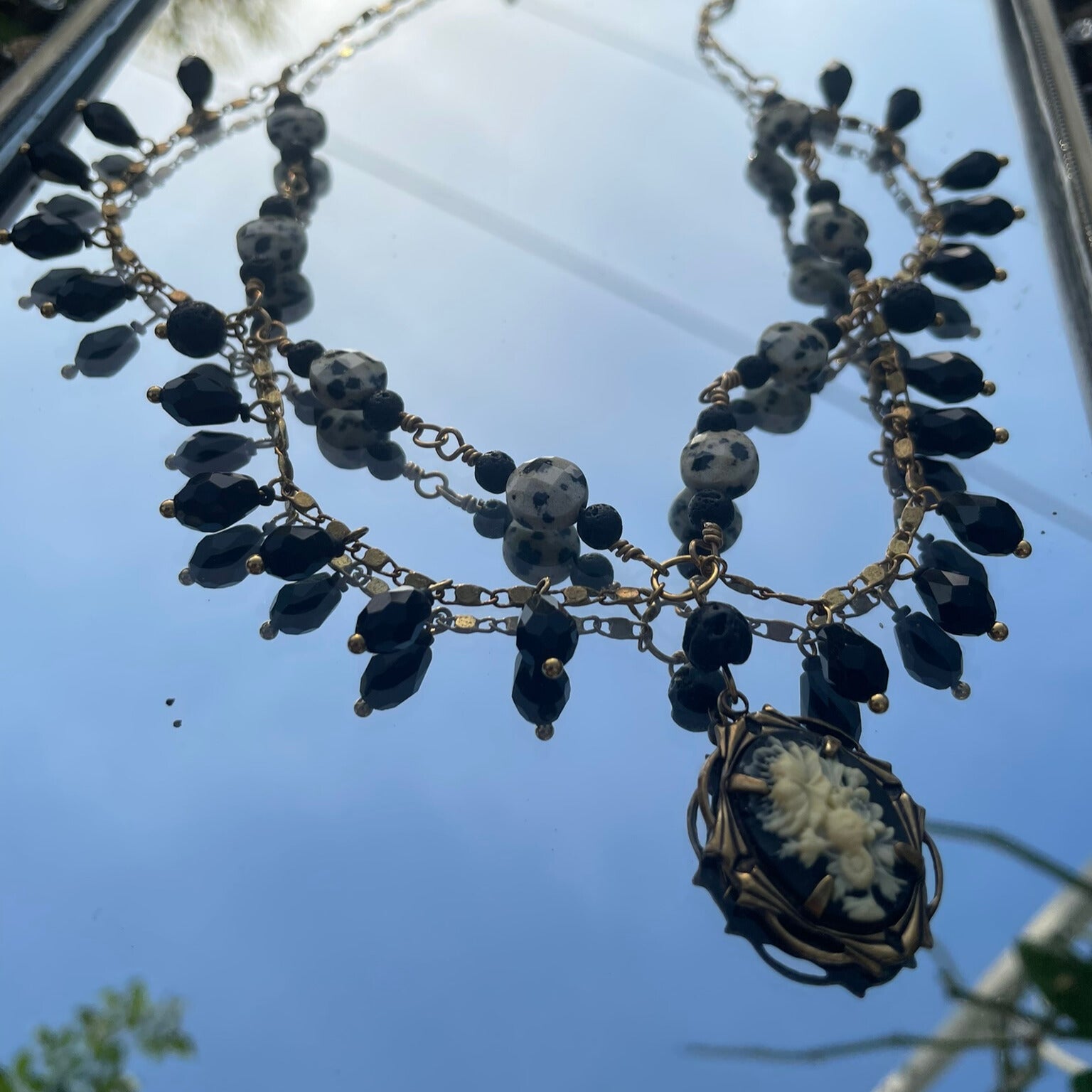 Black and brass beaded statement necklace with cameo charm