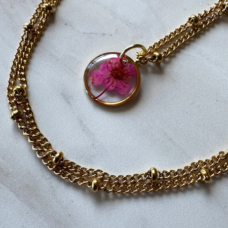 Gold plated resin necklace with fuchsia pink wildflower