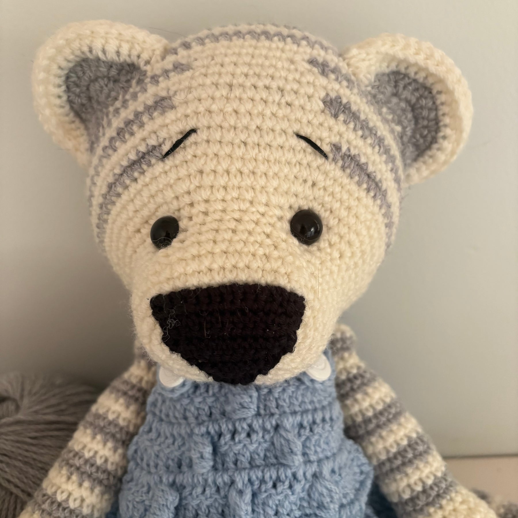 Crochet tiger in blue overalls